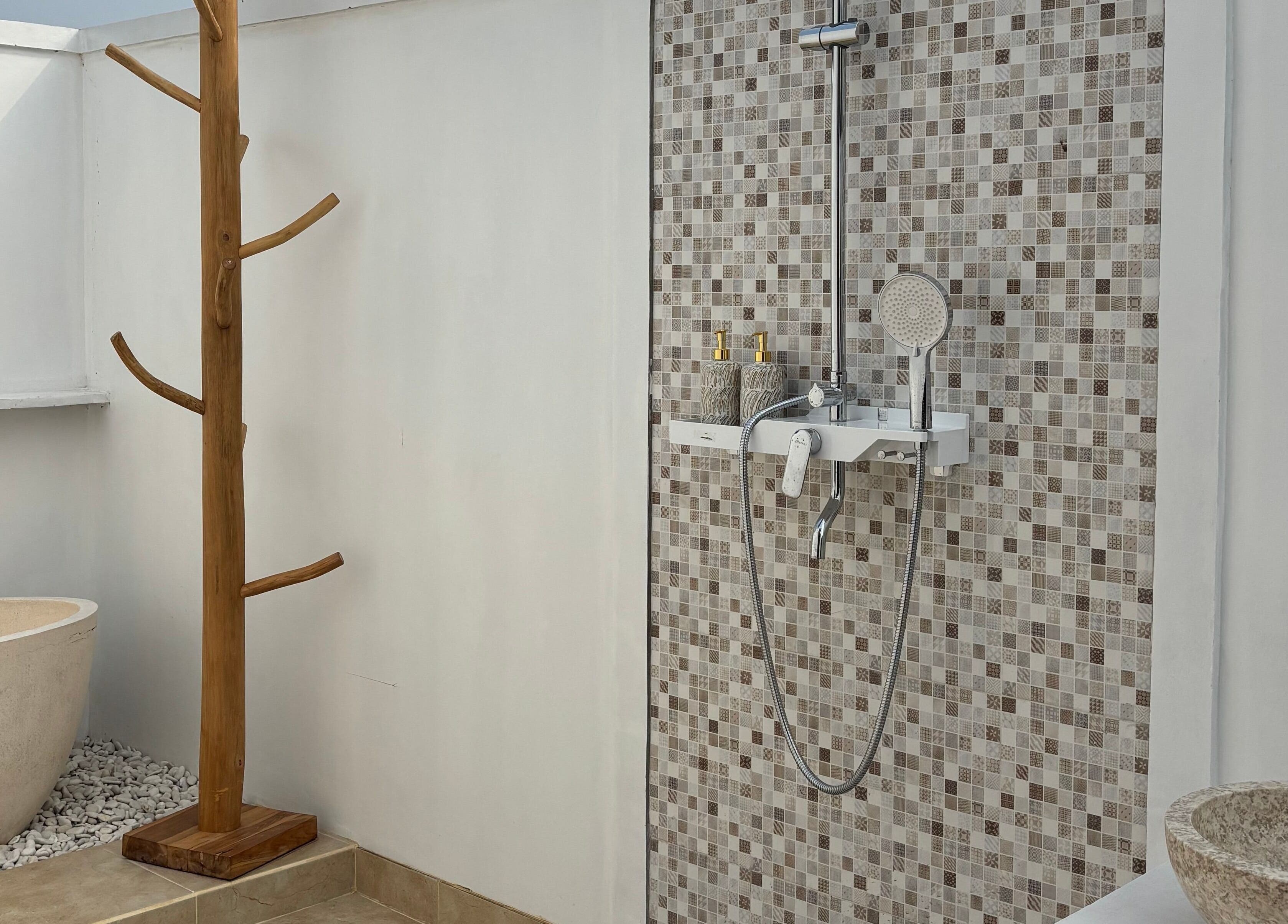 Ruang mandi modern di Chellvan Spa, Bali, Bali, ID dengan dinding mosaik dan bathtub alami.