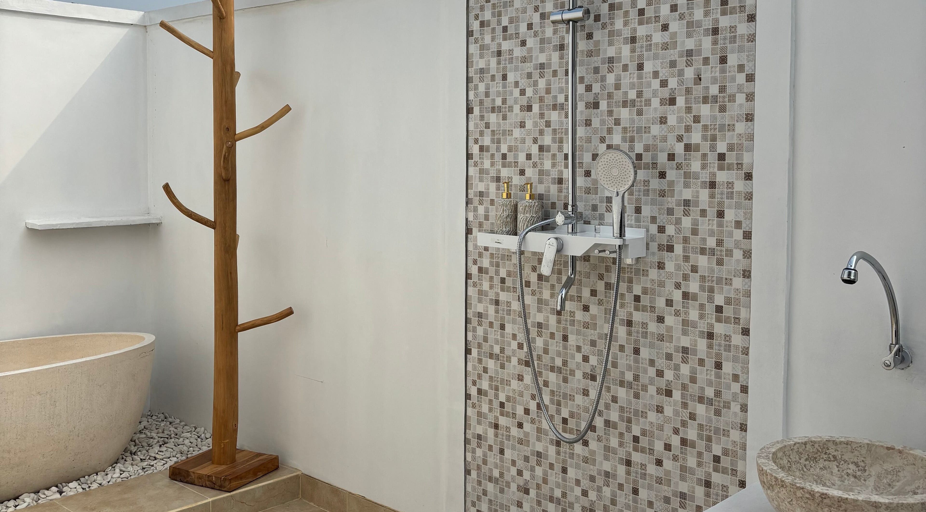 Ruang mandi modern di Chellvan Spa, Bali, Bali, ID dengan dinding mosaik dan bathtub alami.