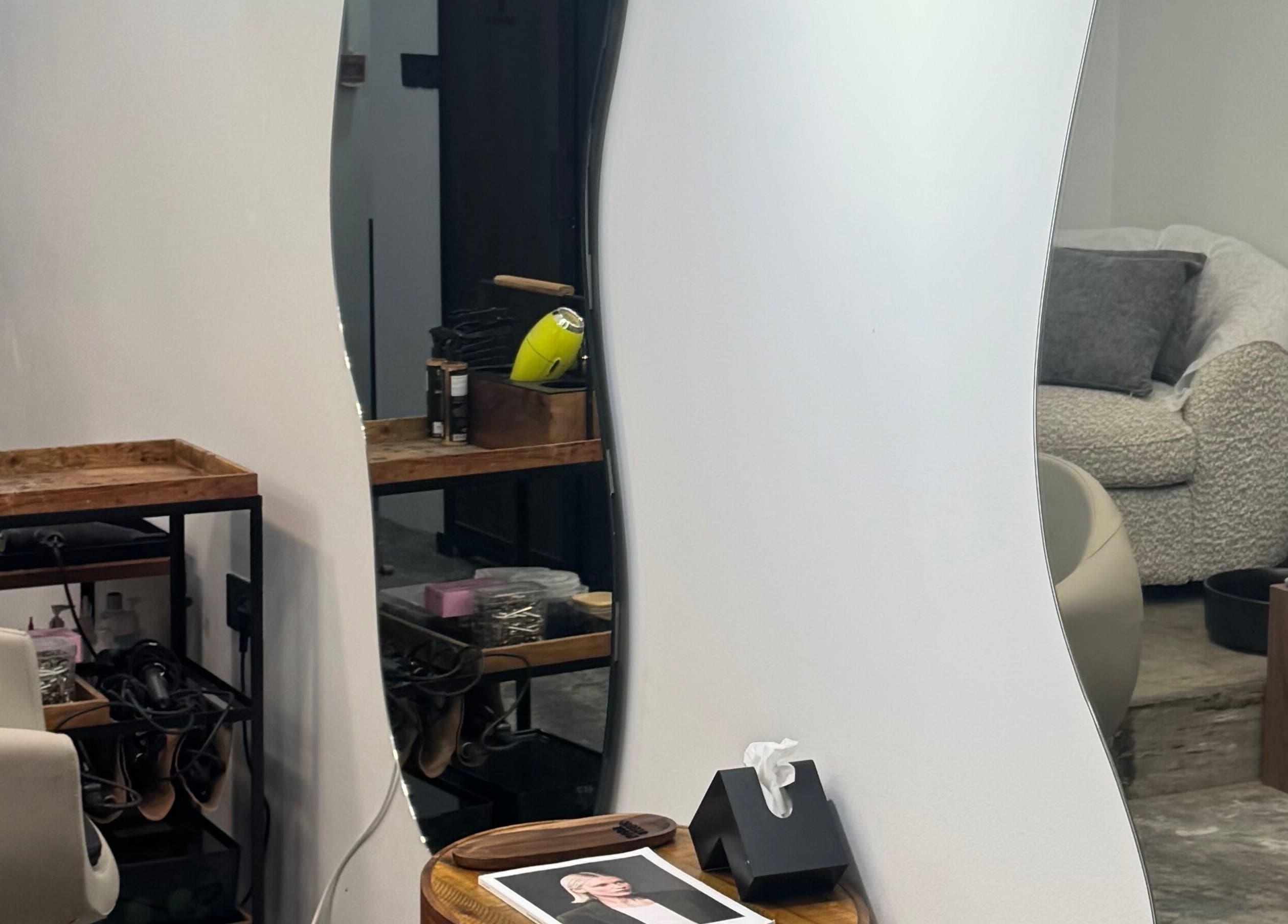 Chic styling station at Ameeri Touch Hair & Beauty, Bu Quwah, BH with modern decor and plush seating.