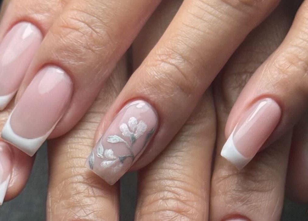 Chic French manicure with floral design at Ameeri Touch Hair & Beauty, Bu Quwah, Bu Quwah, BH.