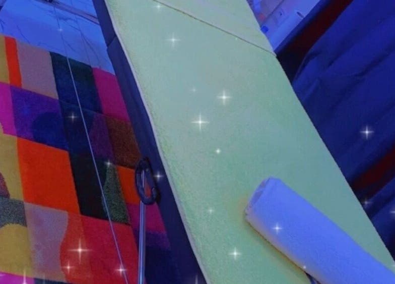 Table de massage chez Bien être By Malaco, Le Havre, Normandie, FR, sur un tapis coloré.