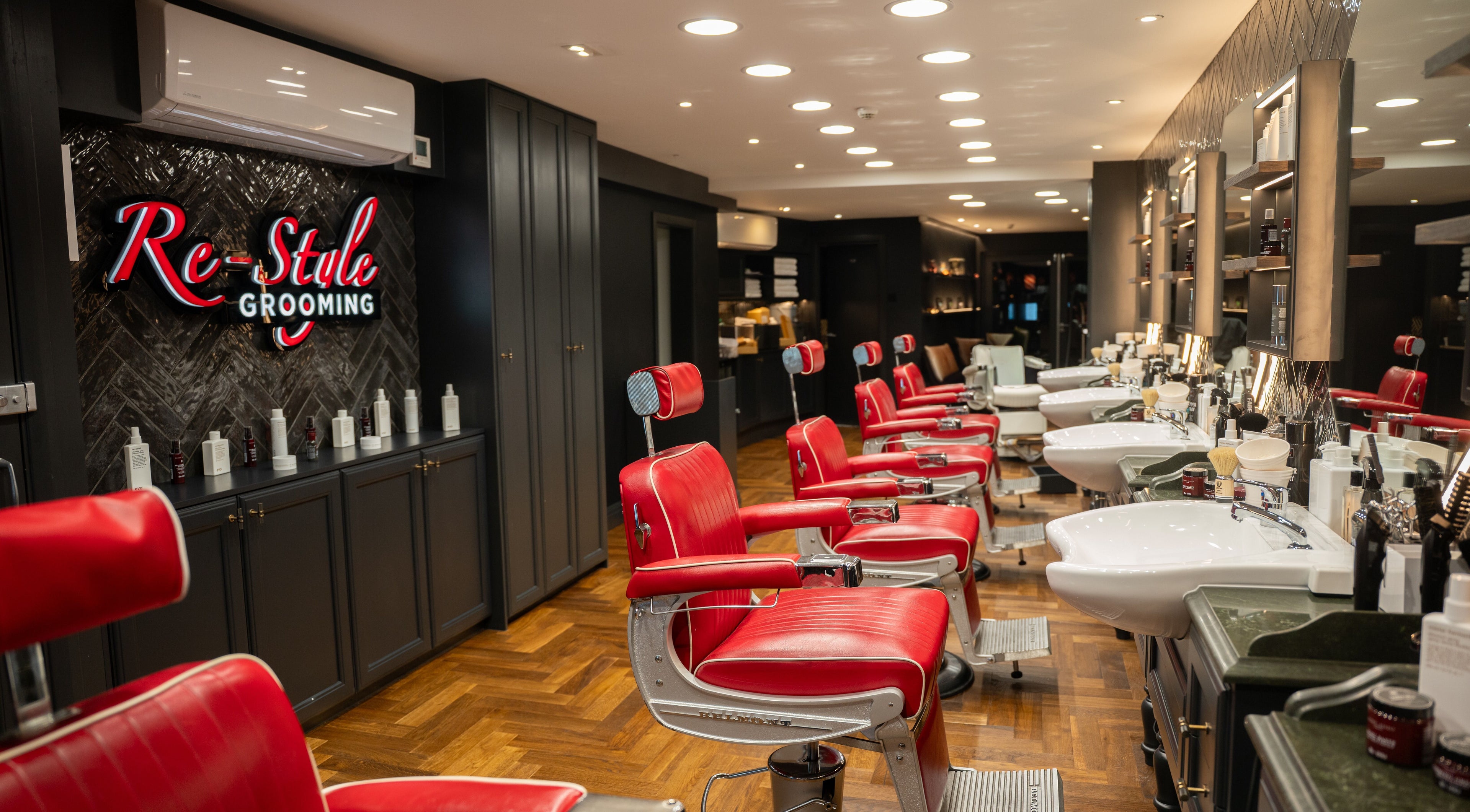 Modern grooming area in Re-Style Highgate, London, England, GB with red chairs and stylish decor.