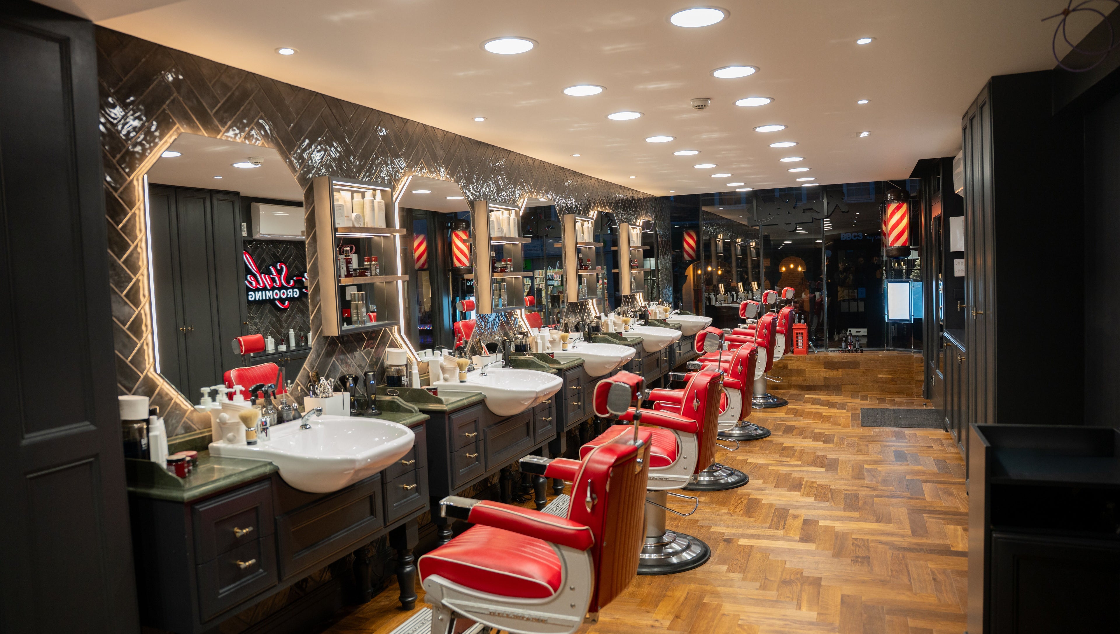 Elegant interior of Re-Style Highgate, a beauty venue in London, England, GB, featuring red barber chairs.