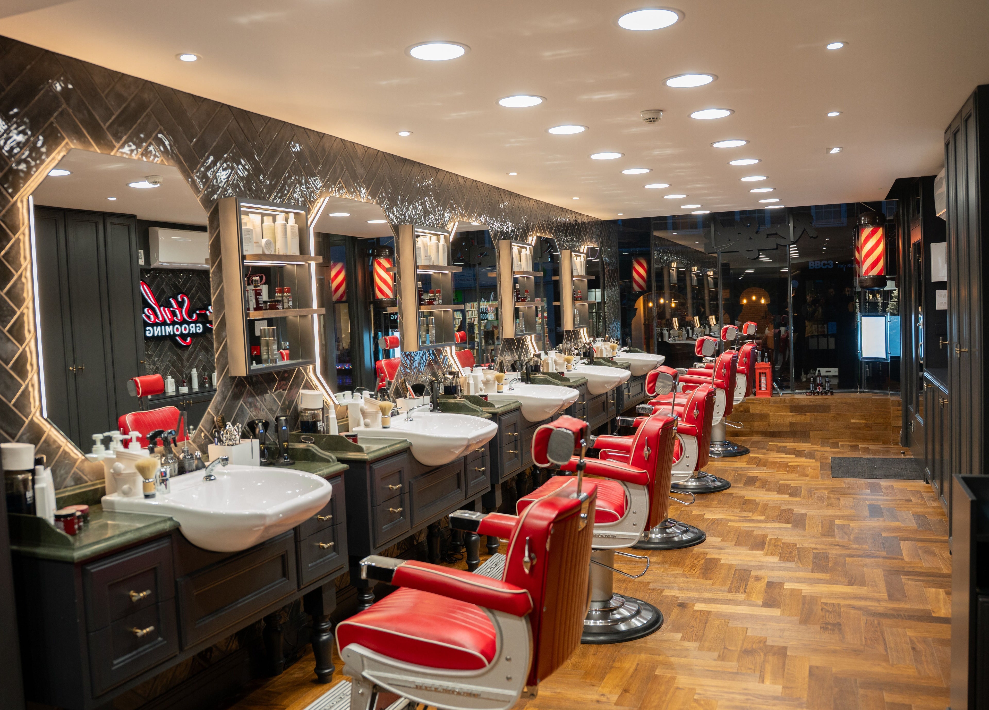 Elegant interior of Re-Style Highgate, a beauty venue in London, England, GB, featuring red barber chairs.