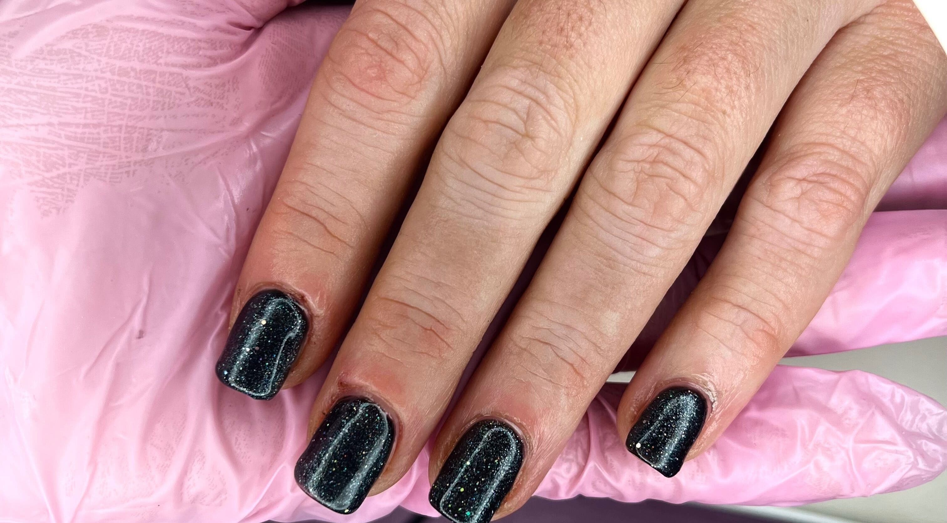 Sparkling black nails at Beautybyjadeleeds, Pudsey, England, GB, highlighted with pink gloves.