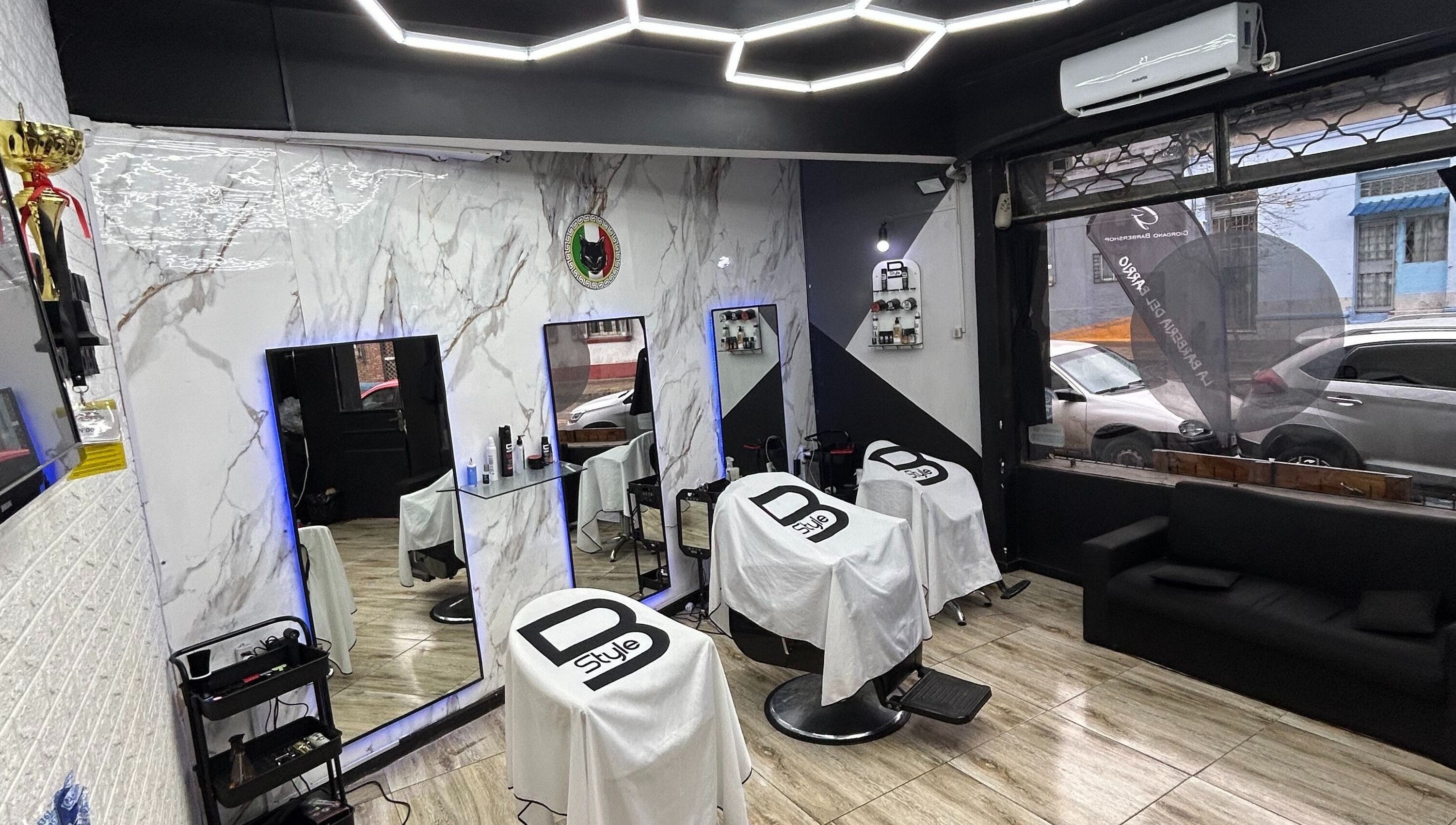 Interior elegante de Giordano BarberShop & Academy en Montevideo, Departamento De Montevideo, UY con espejos iluminados.