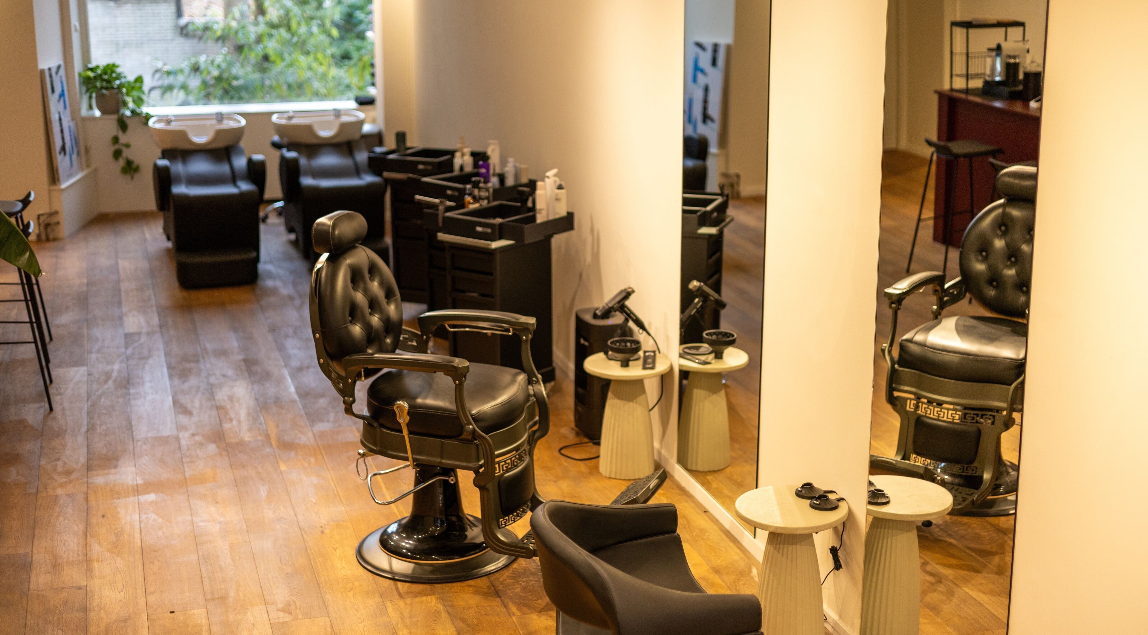 Moderne kappersstoel en wasstations bij HS AMSTERDAM OOST, gelegen in Amsterdam, Noord-Holland, NL.