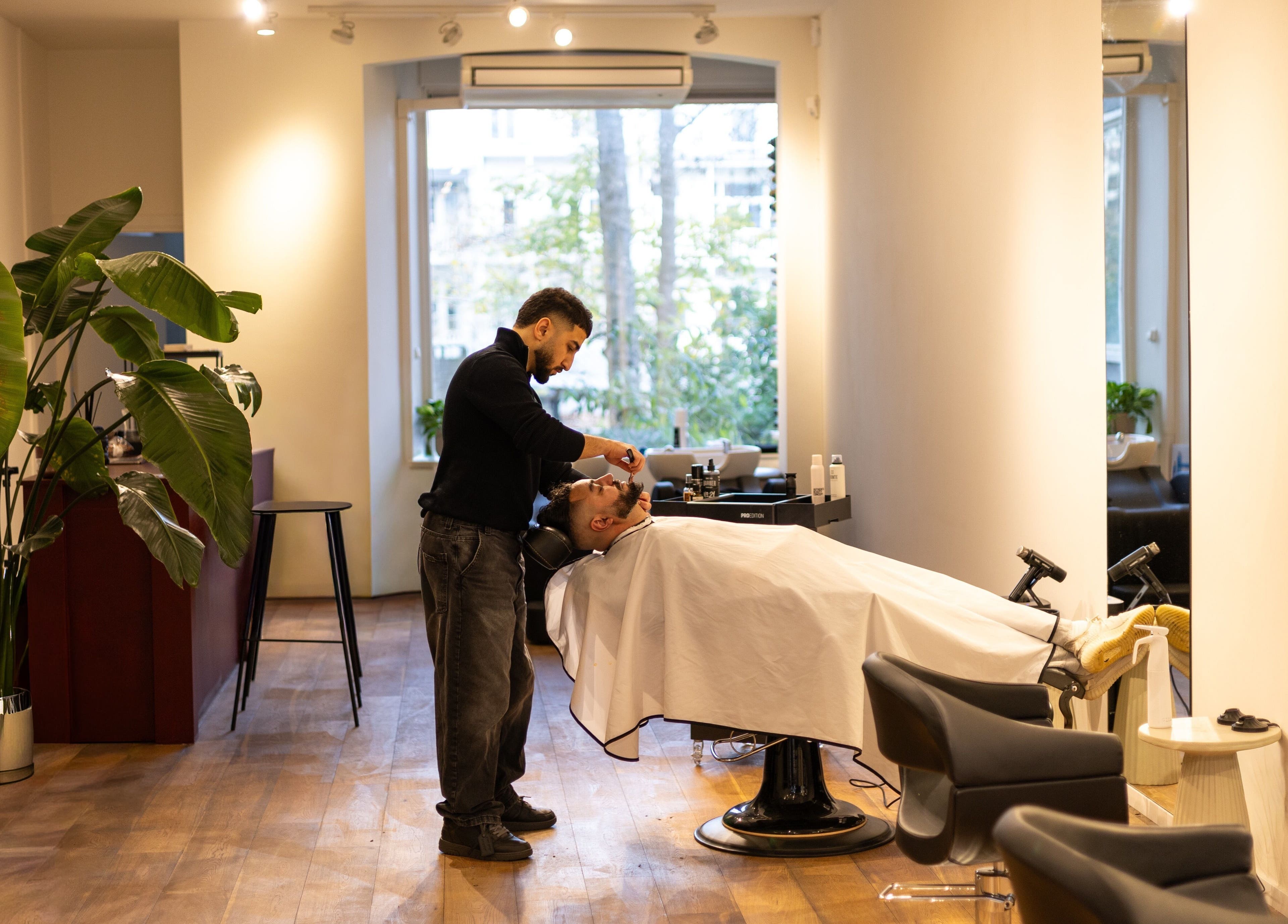 Barbier geeft een knipbeurt bij HS AMSTERDAM OOST, Amsterdam, Noord-Holland, NL.