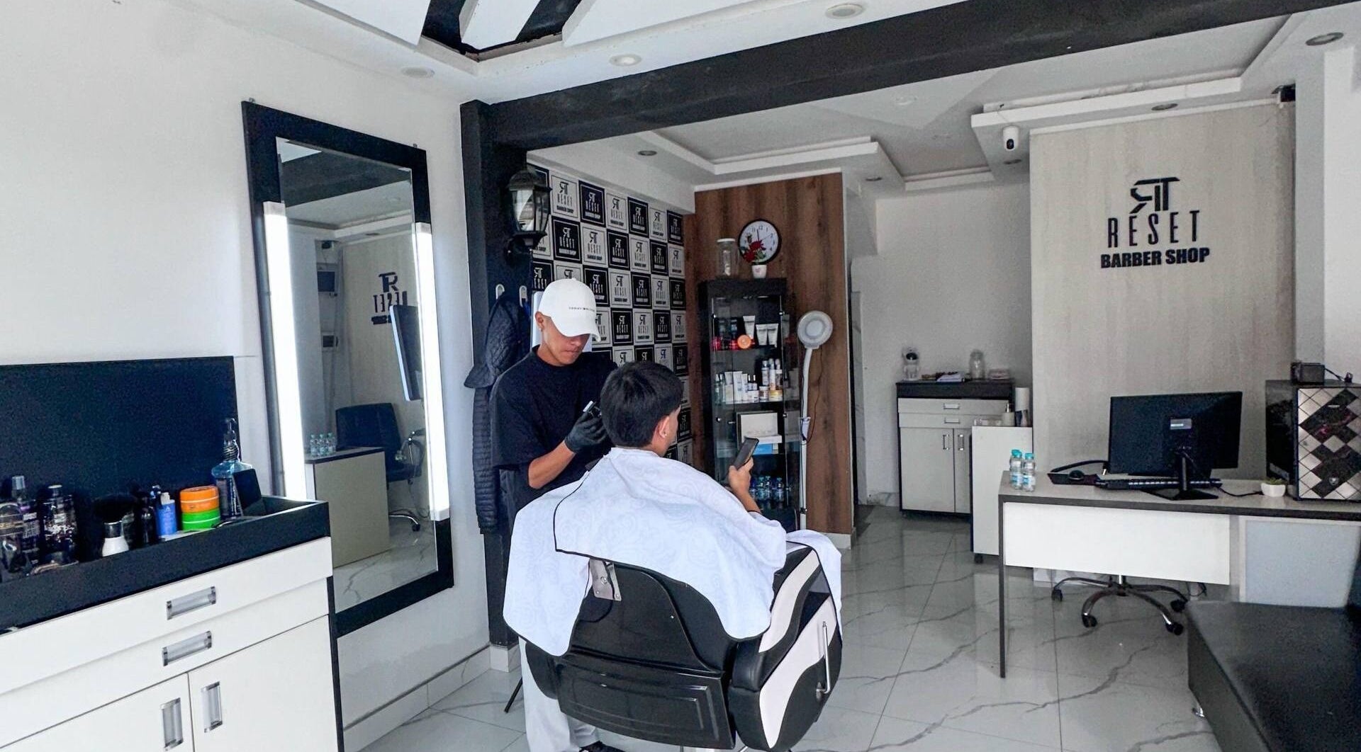 Barbero trabajando cliente en RESET BARBERIA, Ventanilla, Callao, PE, destacando ambiente elegante.