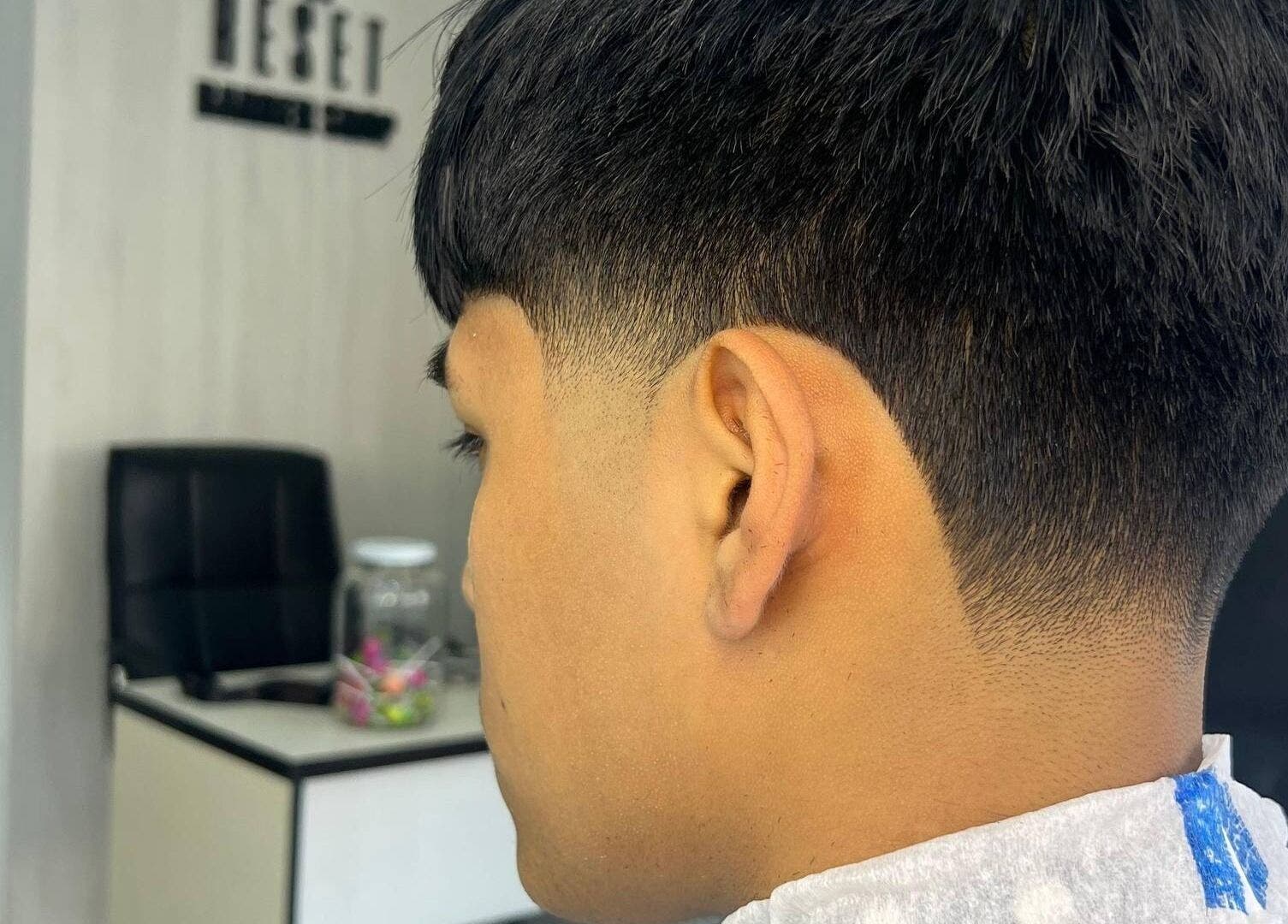 Corte fresco en RESET BARBERIA, Ventanilla, Callao, PE, mostrando el detalle de un degradado perfecto.