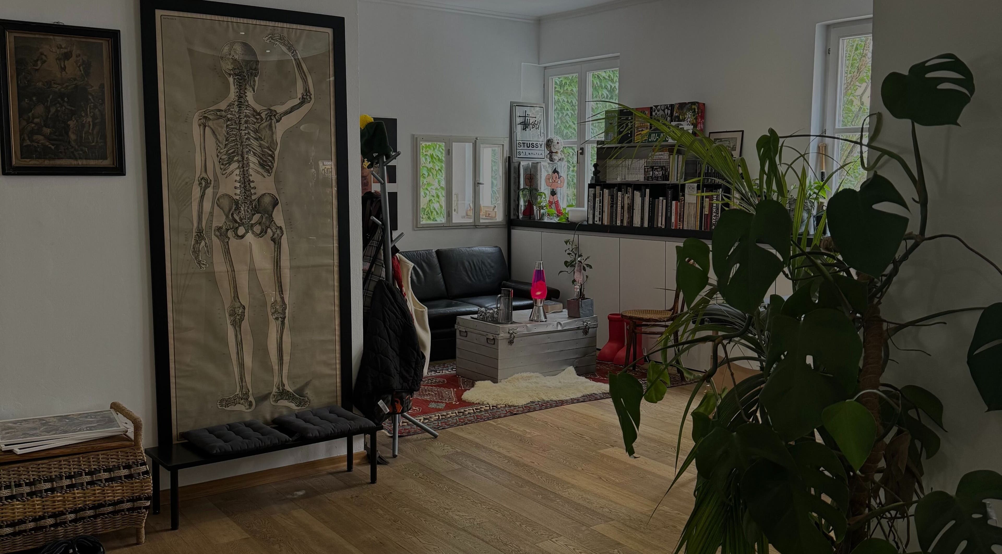 Stilvolle Lounge bei DANUVUE ART / GALLERY / TATTOO in München, Bayern, DE mit Skelettkunst und Pflanzen.