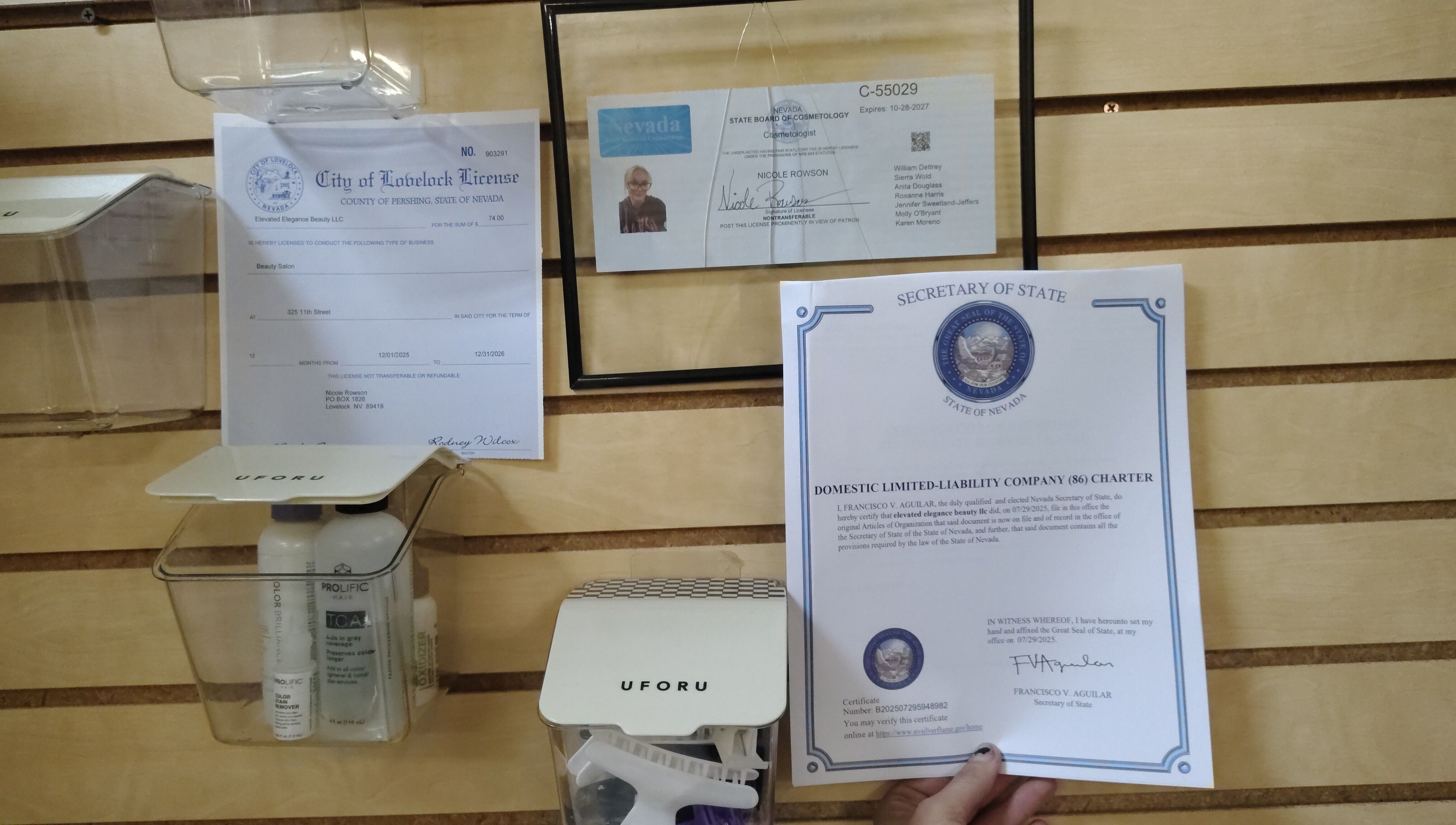 Elevated Elegance Beauty licenses on wood wall in Lovelock, Nevada, US, showcasing certifications.