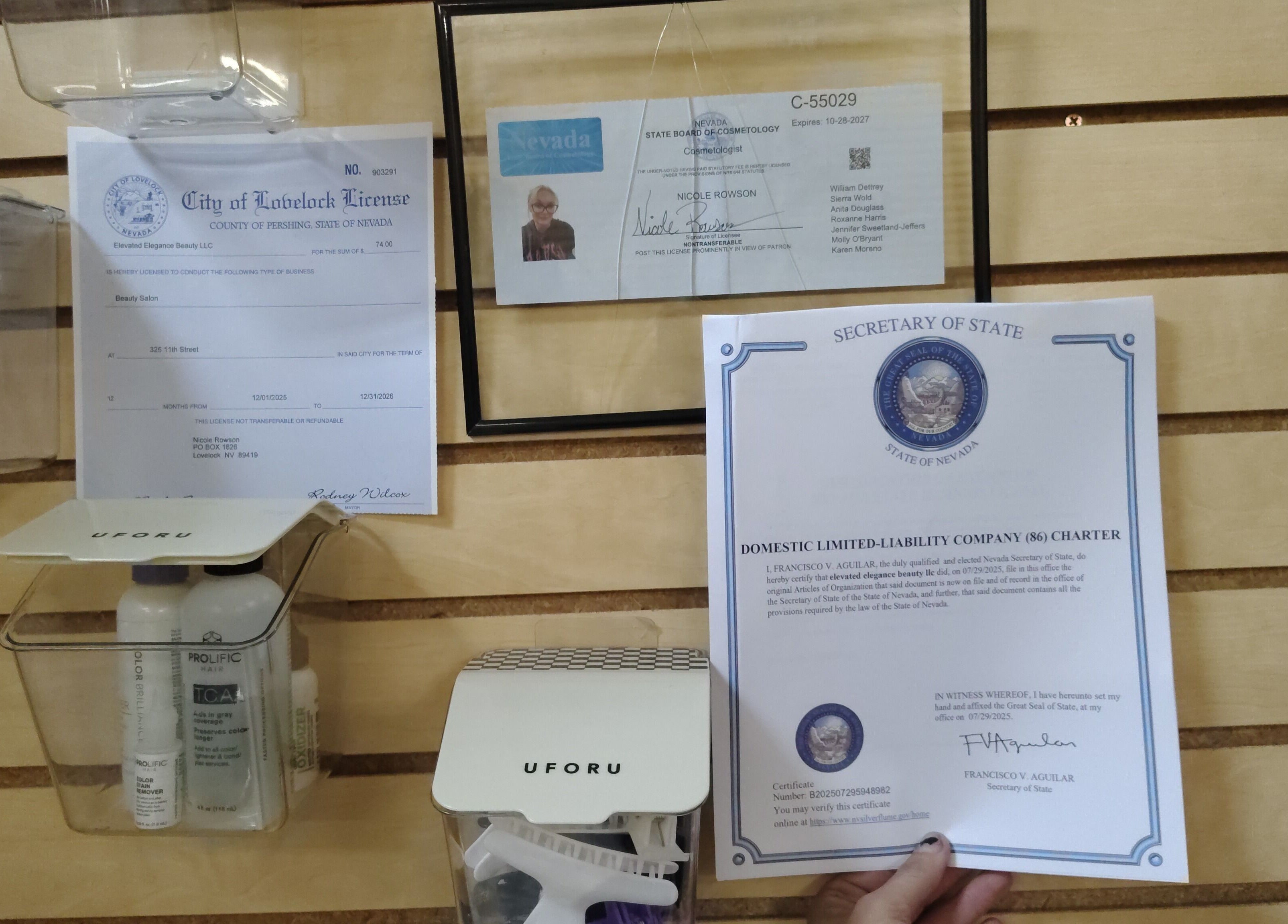 Elevated Elegance Beauty licenses on wood wall in Lovelock, Nevada, US, showcasing certifications.