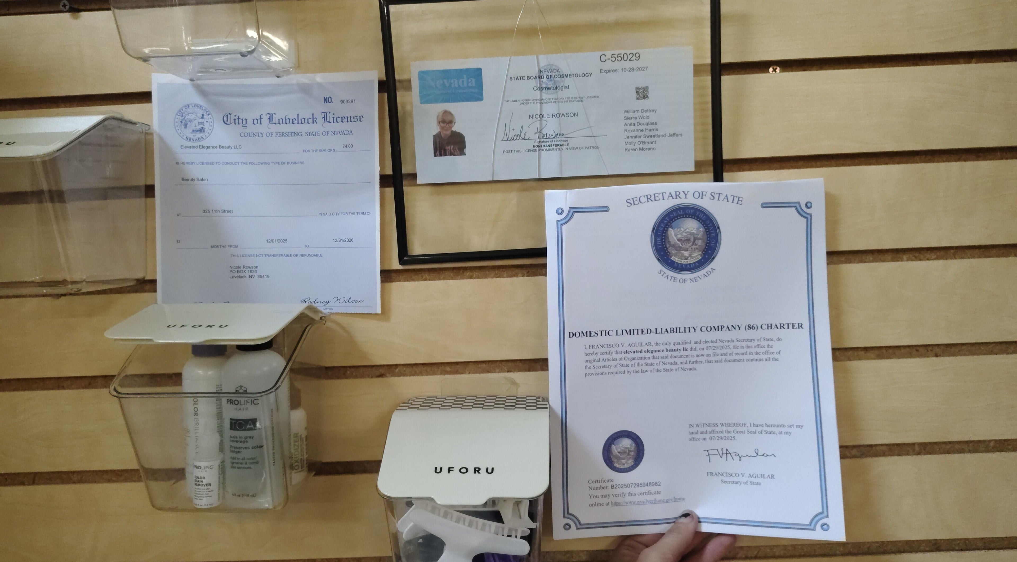 Elevated Elegance Beauty licenses on wood wall in Lovelock, Nevada, US, showcasing certifications.