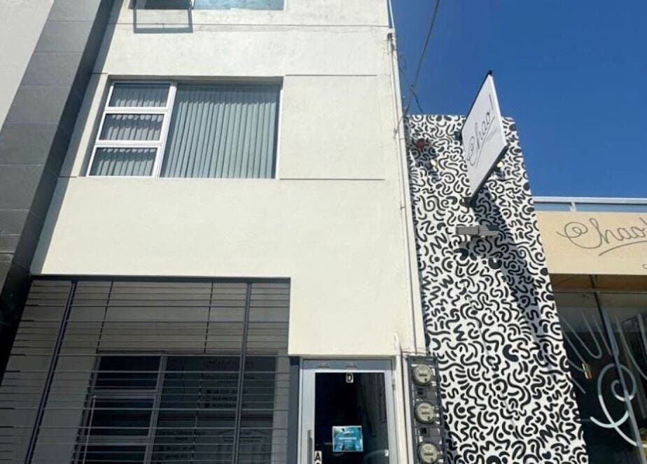 Entrance of XERŪM Wellness Spa, Tijuana, Baja California, MX, with modern facade and intricate mural design.