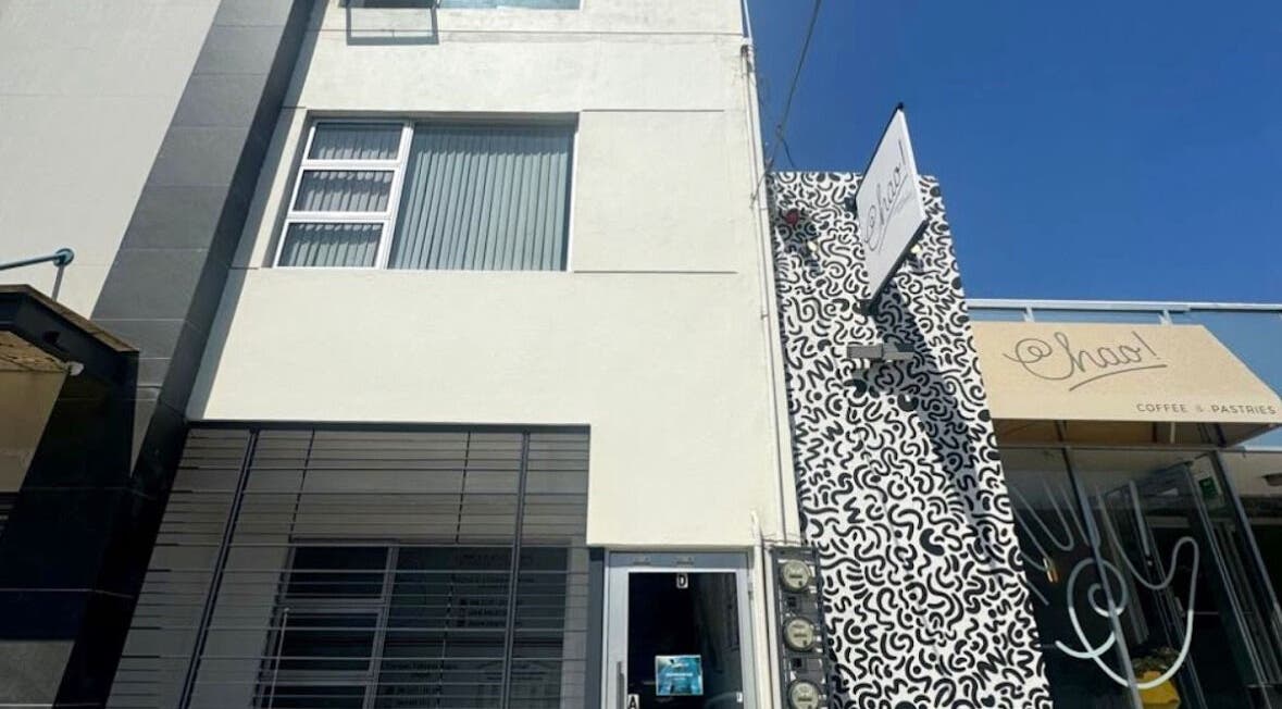 Entrance of XERŪM Wellness Spa, Tijuana, Baja California, MX, with modern facade and intricate mural design.