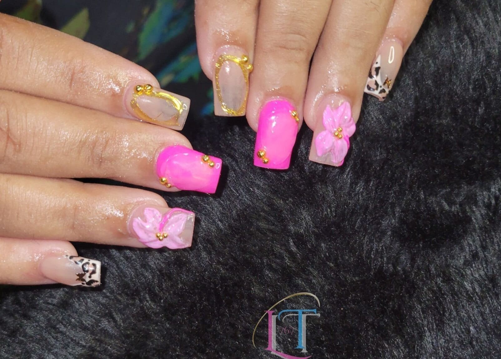Elegant floral nail art at LilysTouch767, Saint David Parish, DM, showcasing vibrant pink and gold accents.