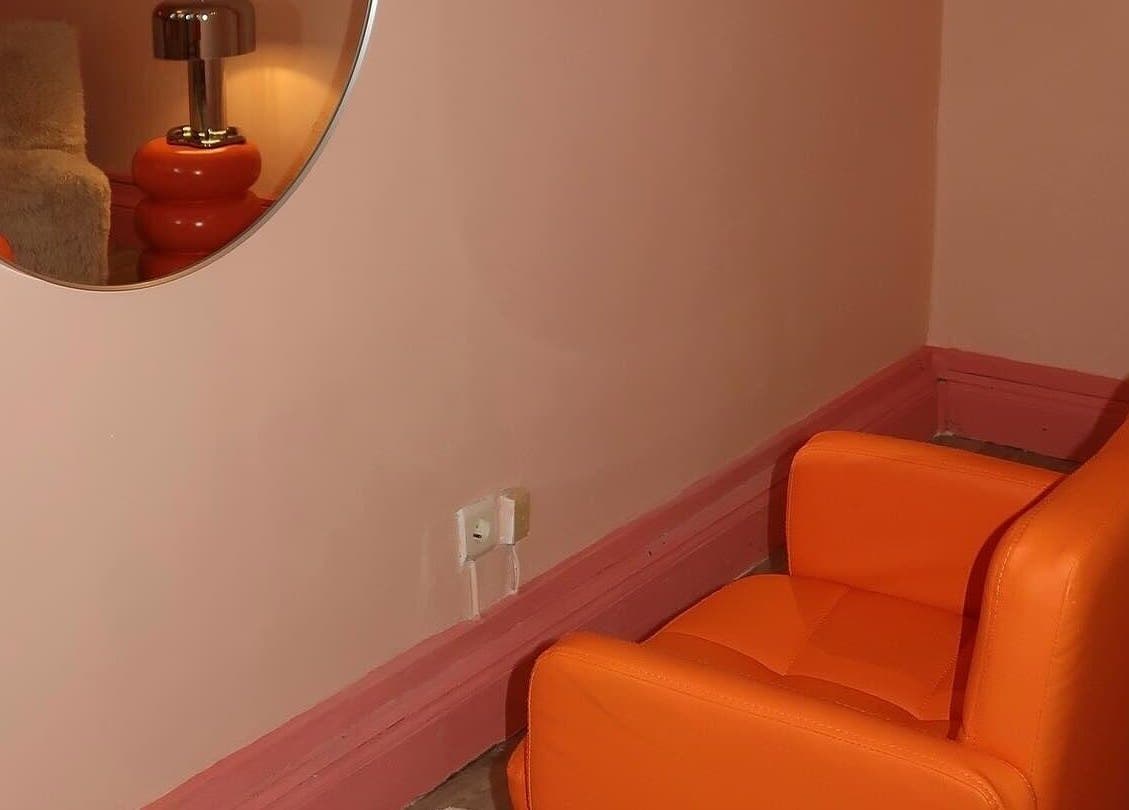 Fauteuil orange confortable chez Glowima, Mons, Région Wallonne, BE. Ambiance chaleureuse et moderne.