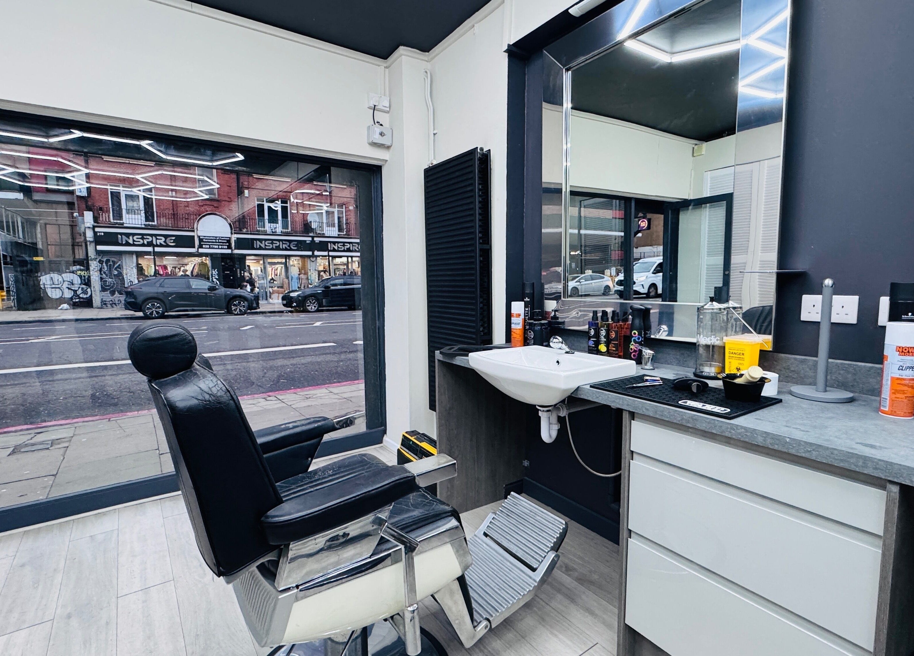 Interior of Danny's Barber in London, England, GB showcasing sleek chair and modern styling area.