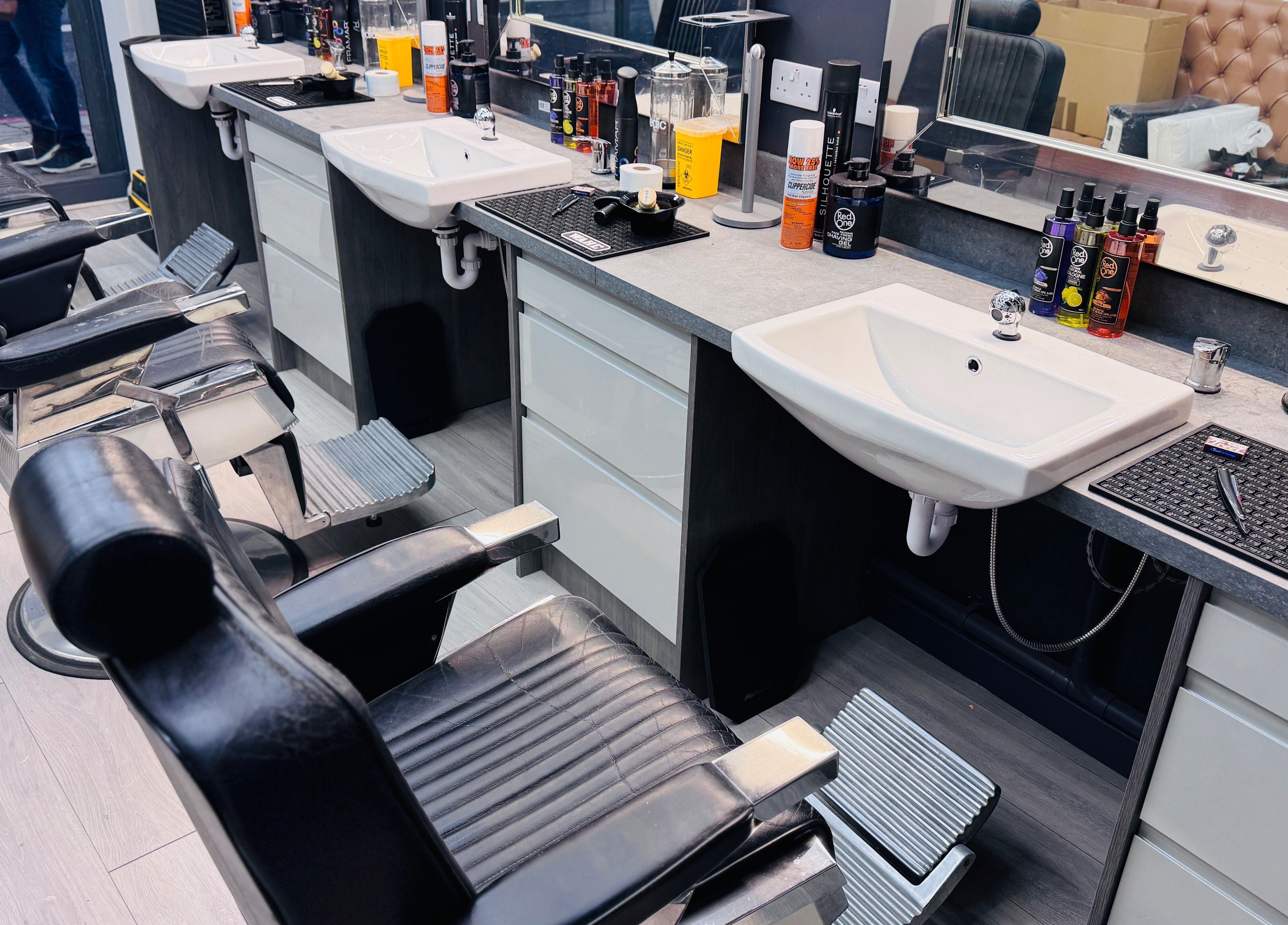 Modern barber chairs and sinks at Danny’s Barber in London, England, GB, showcasing sleek design.