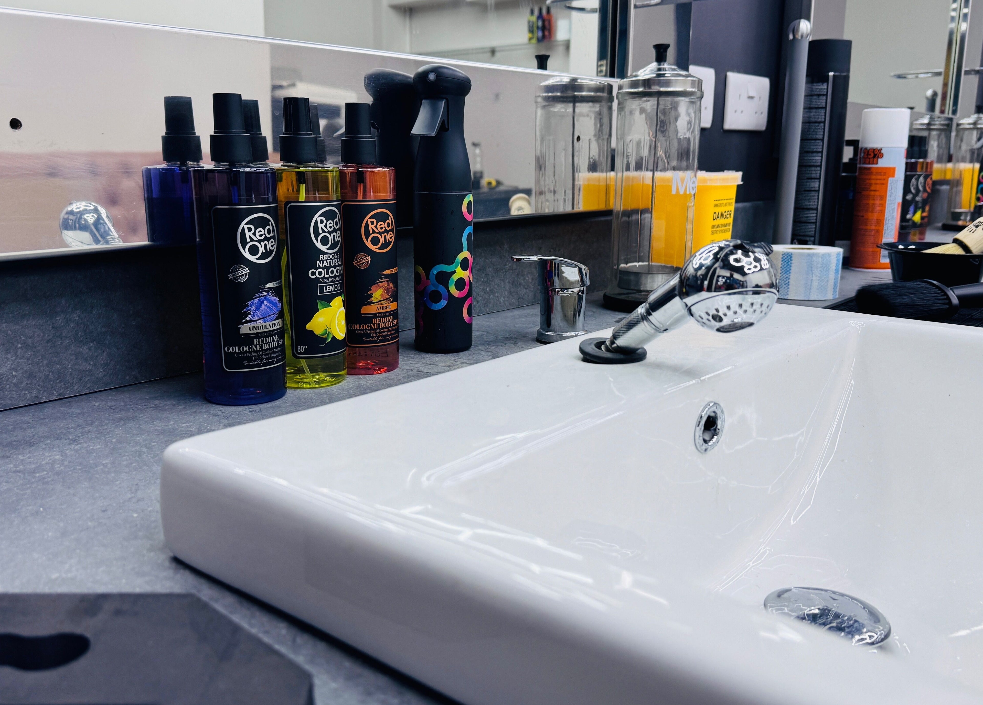 Grooming products on counter at Danny’s Barber, London, England, GB, showcasing sleek salon ambiance.