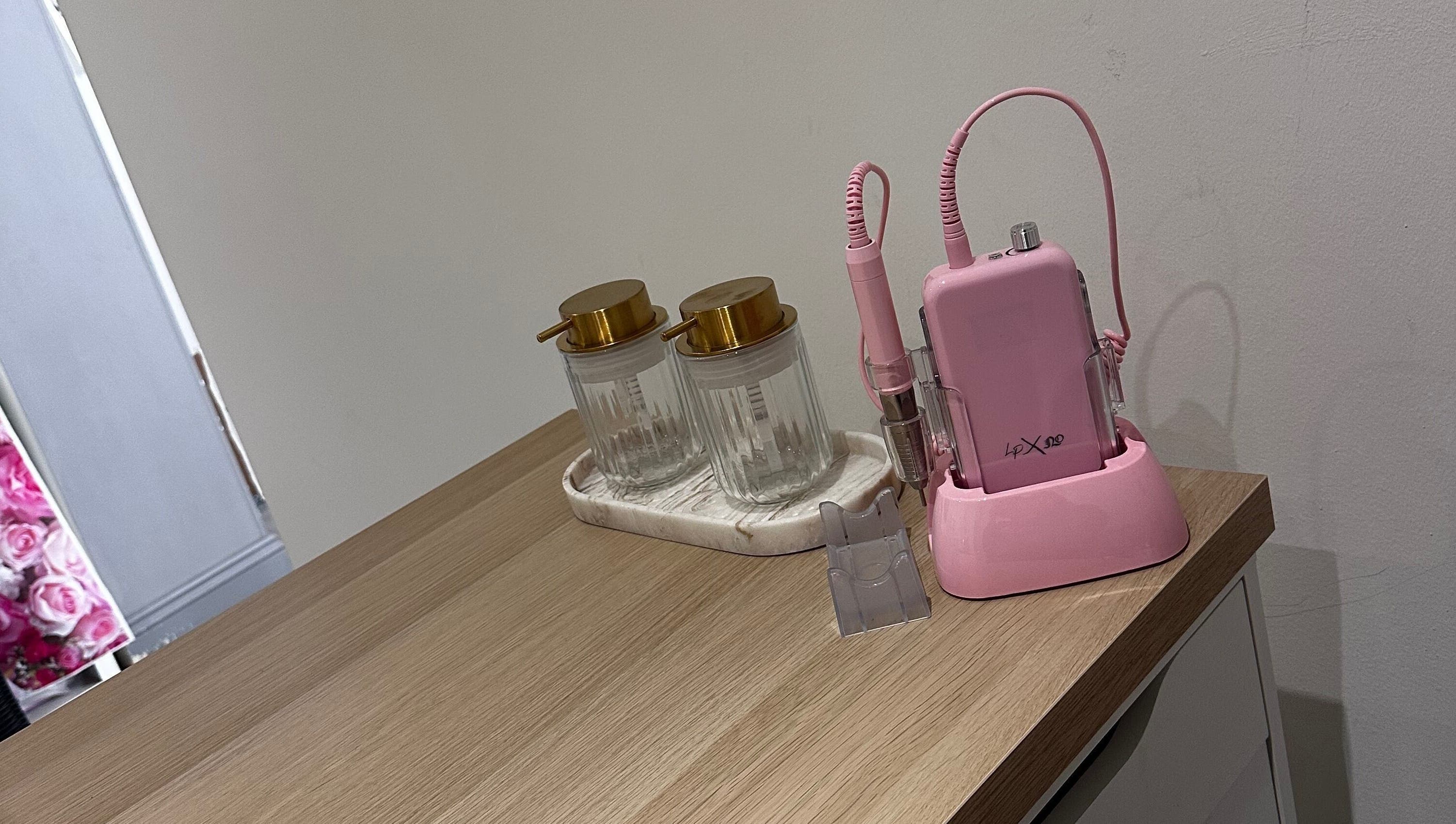 Modern nail equipment at Nails by Mack, Lanark, Scotland, GB, featuring pink drill and stylish jars.