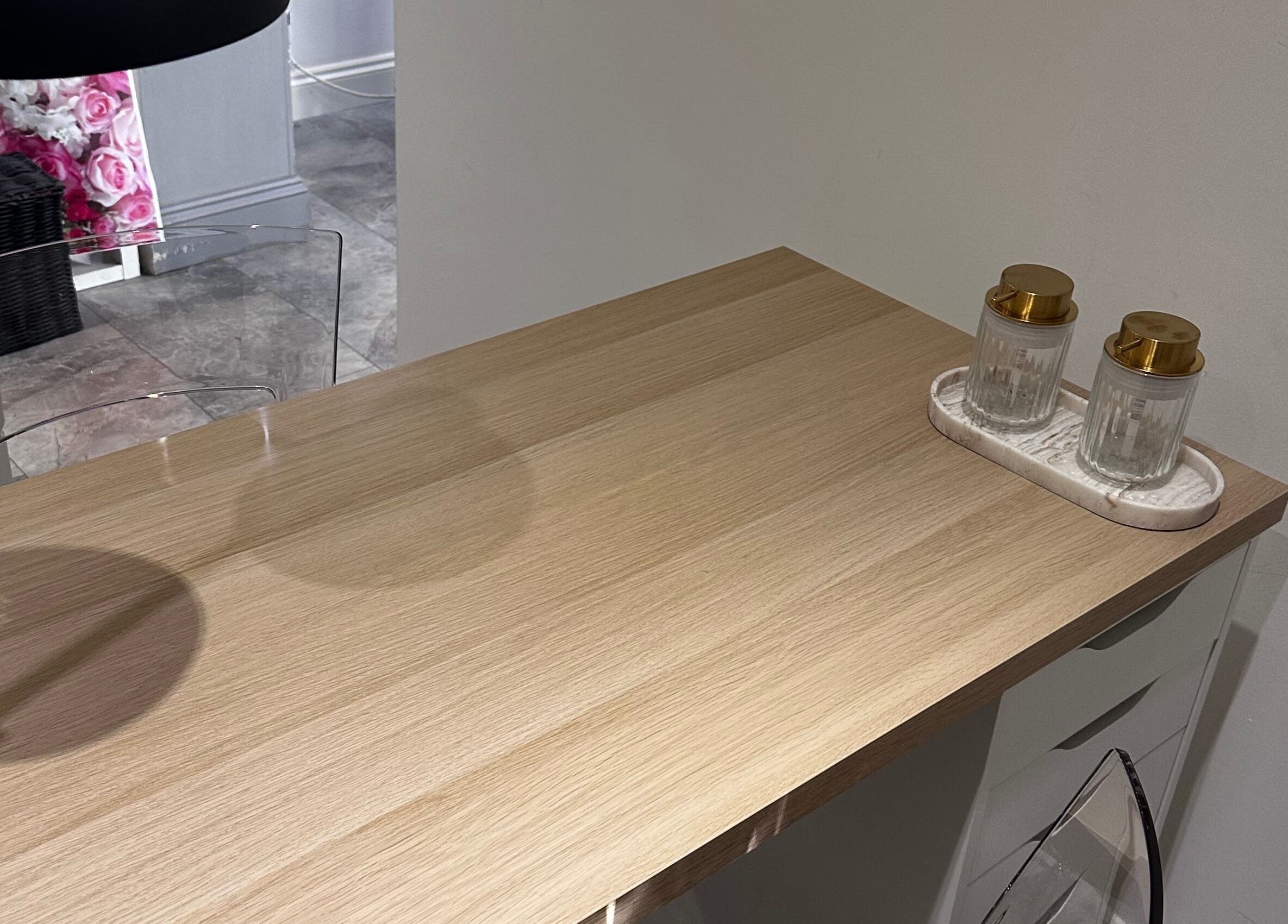 Sleek wooden nail table at Nails by Mack in Lanark, Scotland, GB, with two decorative jars.