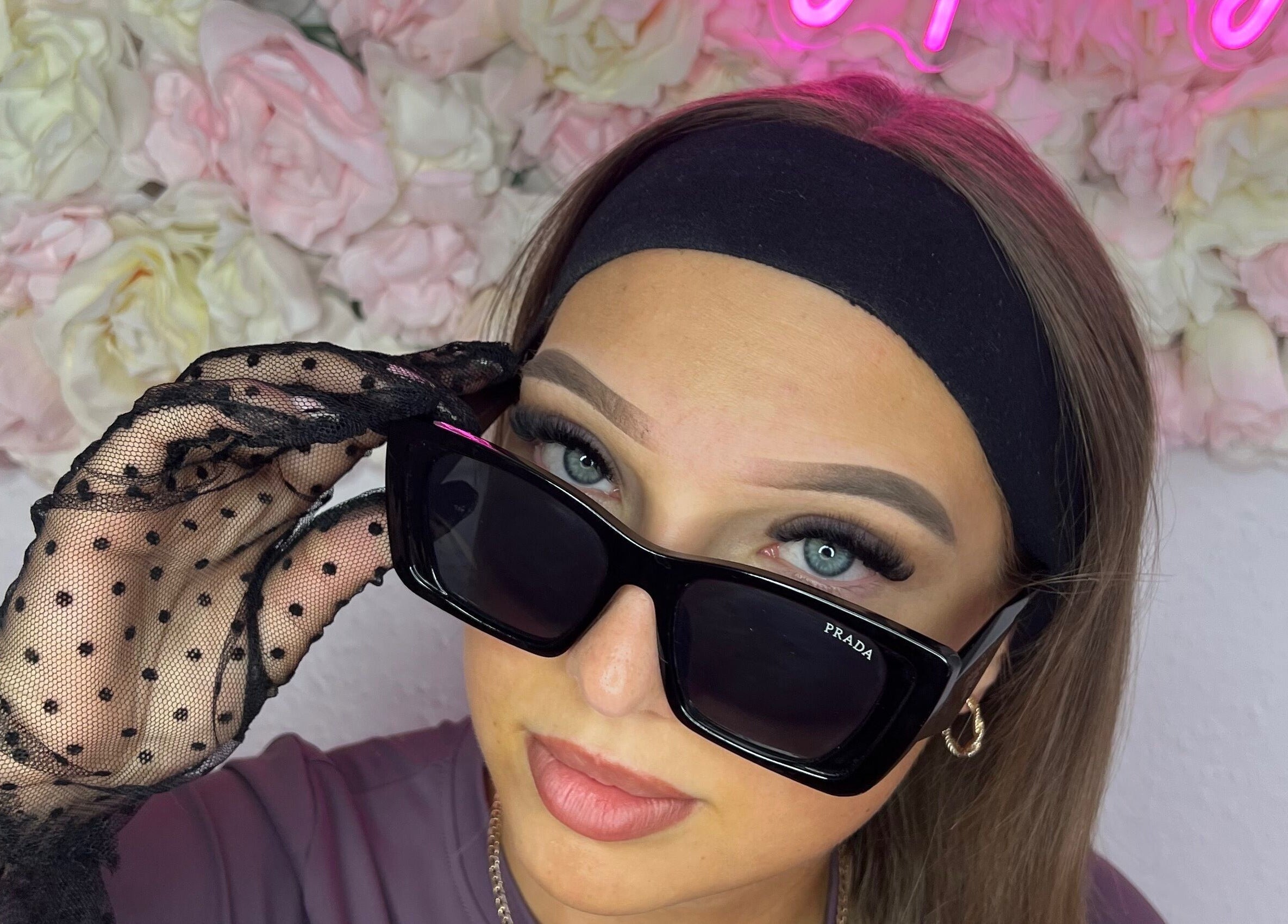 Stylish woman in sunglasses at Linda.Lashes.Rugby, Rugby, England, GB with floral background.