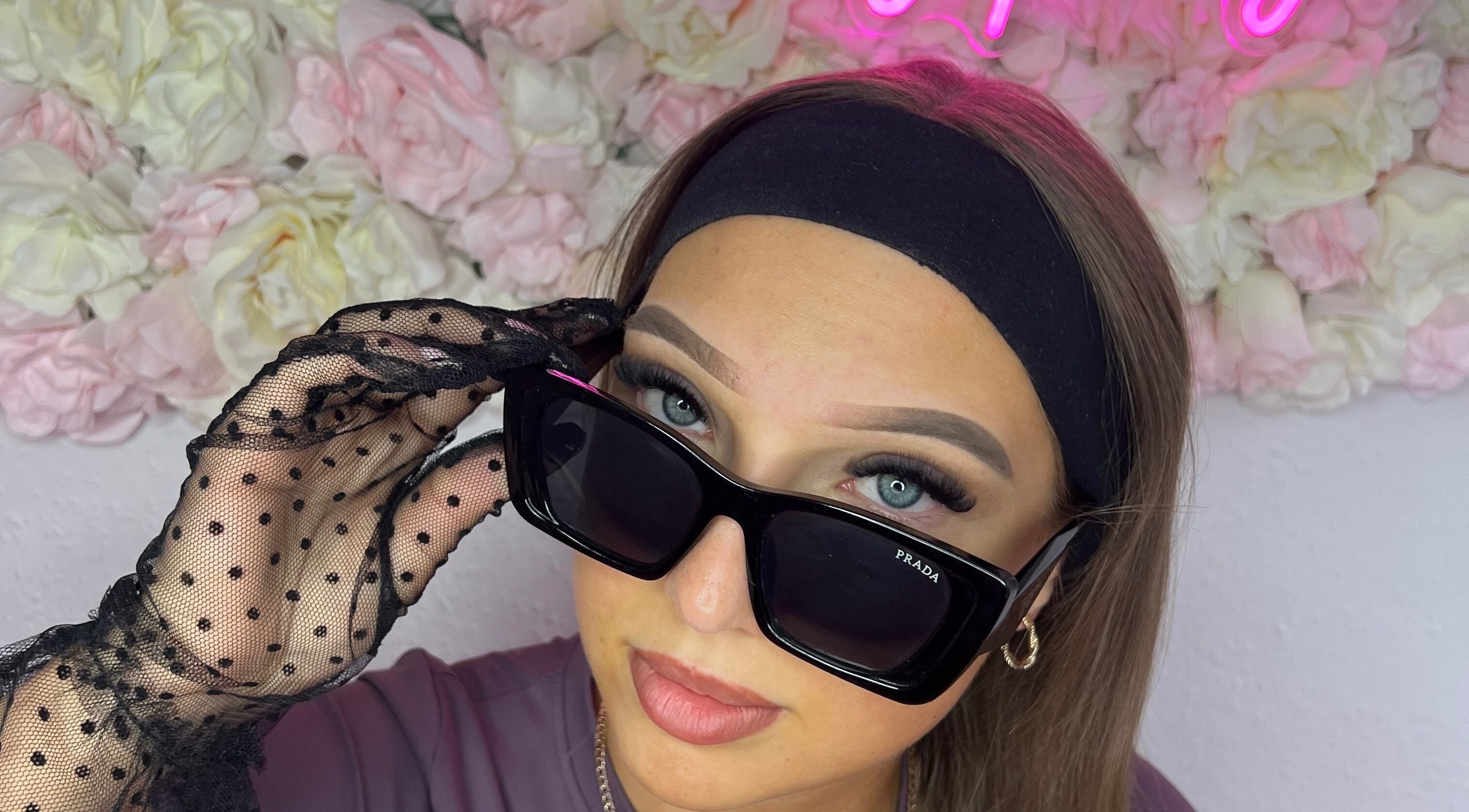 Stylish woman in sunglasses at Linda.Lashes.Rugby, Rugby, England, GB with floral background.