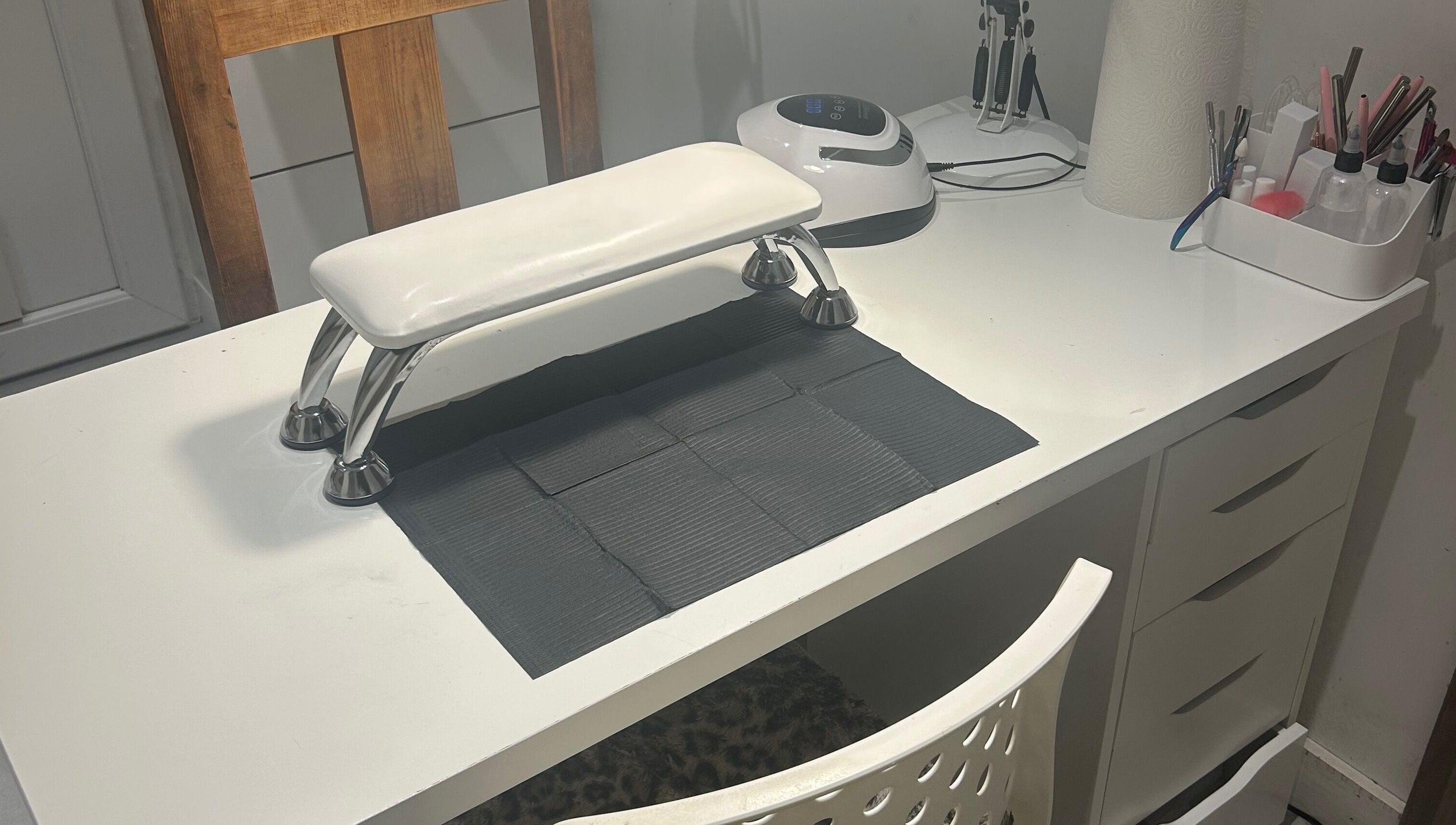 Modern nail station at nai.lsbyemilia, Saint Kew, England, GB, featuring tools and equipment on a sleek white desk.