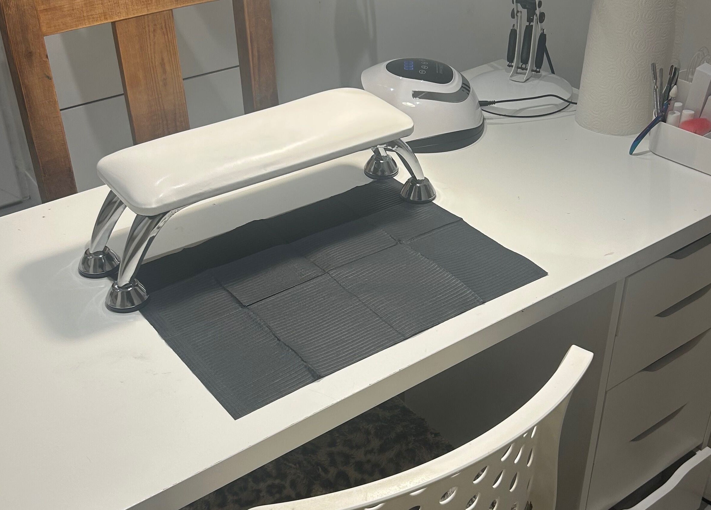 Modern nail station at nai.lsbyemilia, Saint Kew, England, GB, featuring tools and equipment on a sleek white desk.