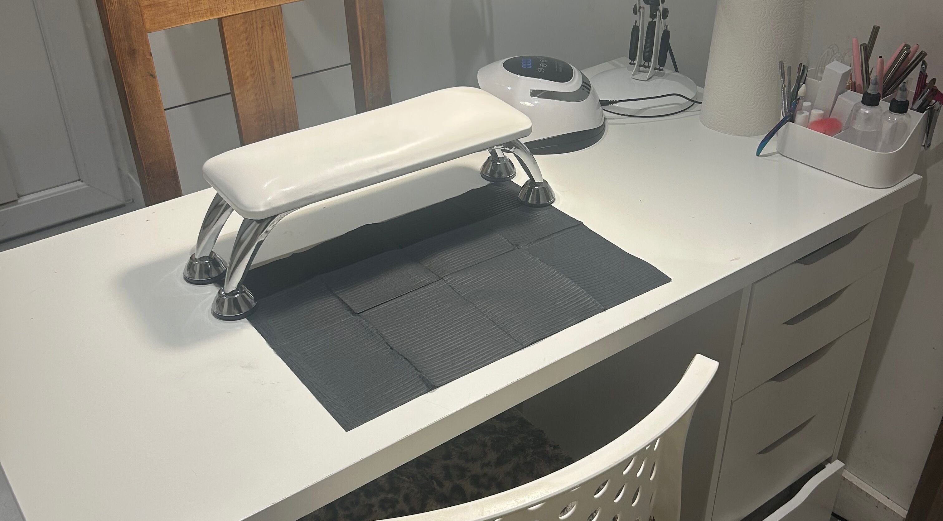 Modern nail station at nai.lsbyemilia, Saint Kew, England, GB, featuring tools and equipment on a sleek white desk.