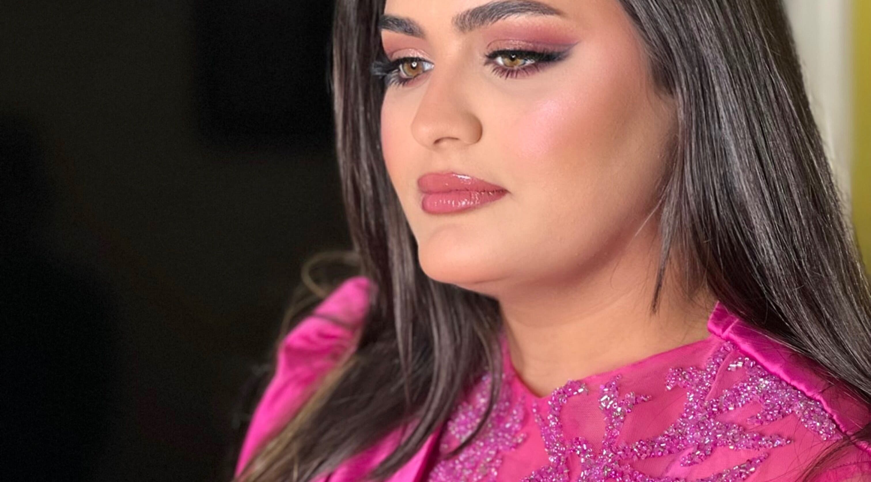 Woman in glamorous pink attire at Glam by Sara, Harrisburg, Pennsylvania, US, showcasing vibrant makeup.