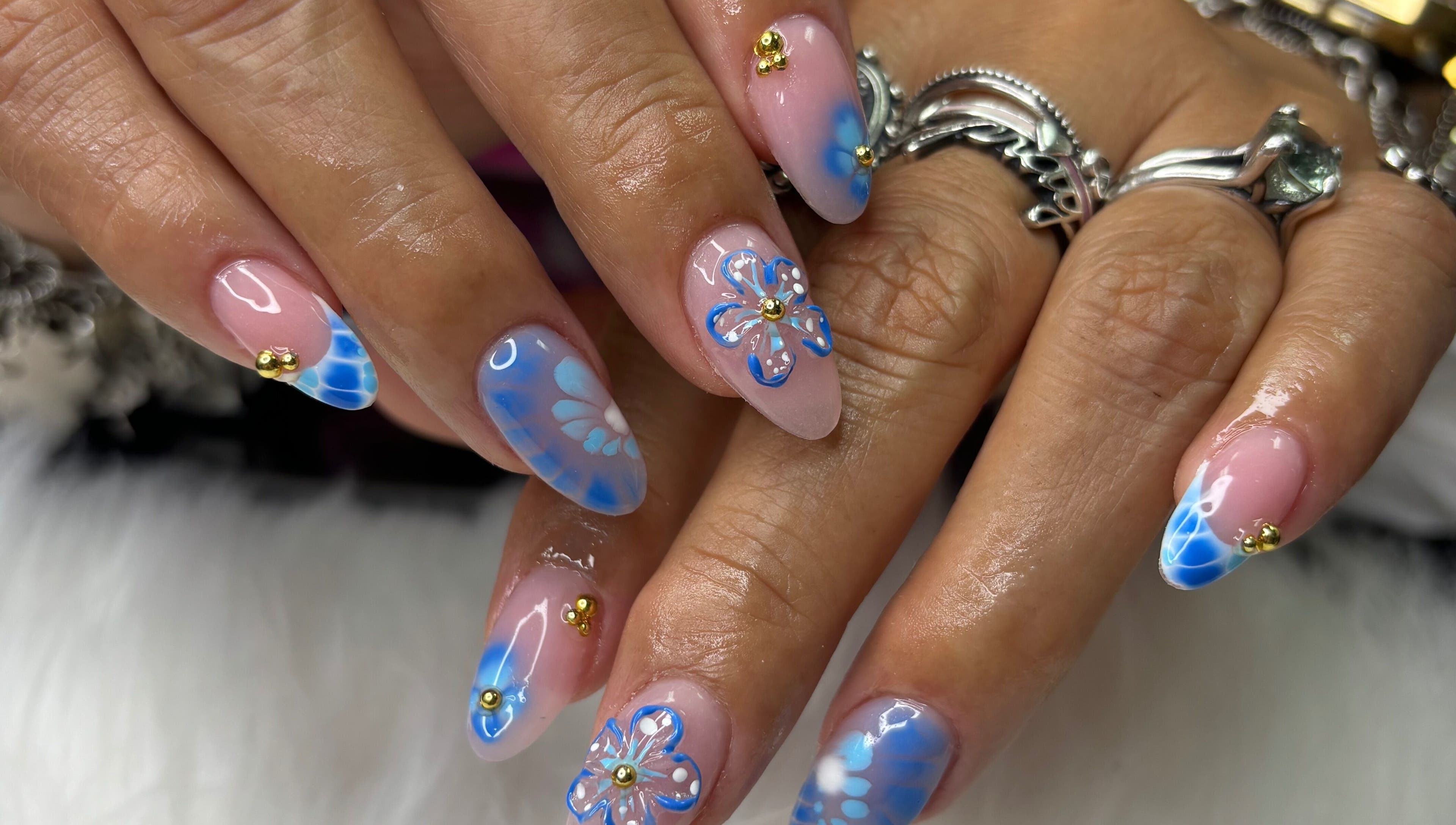 Intricate blue floral nails at Destiny's nail room in San Antonio, Texas, US. Unique nail art design.