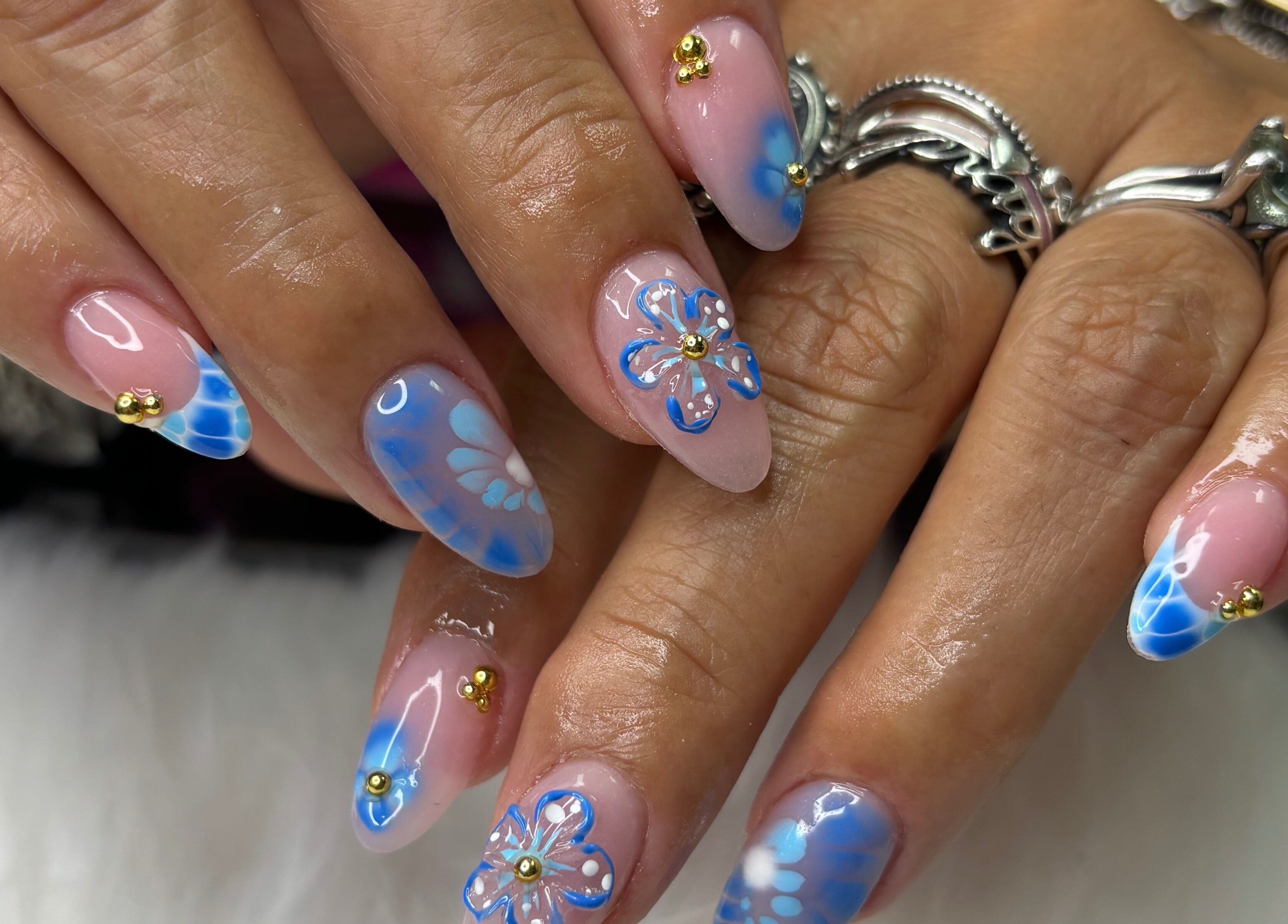 Intricate blue floral nails at Destiny's nail room in San Antonio, Texas, US. Unique nail art design.