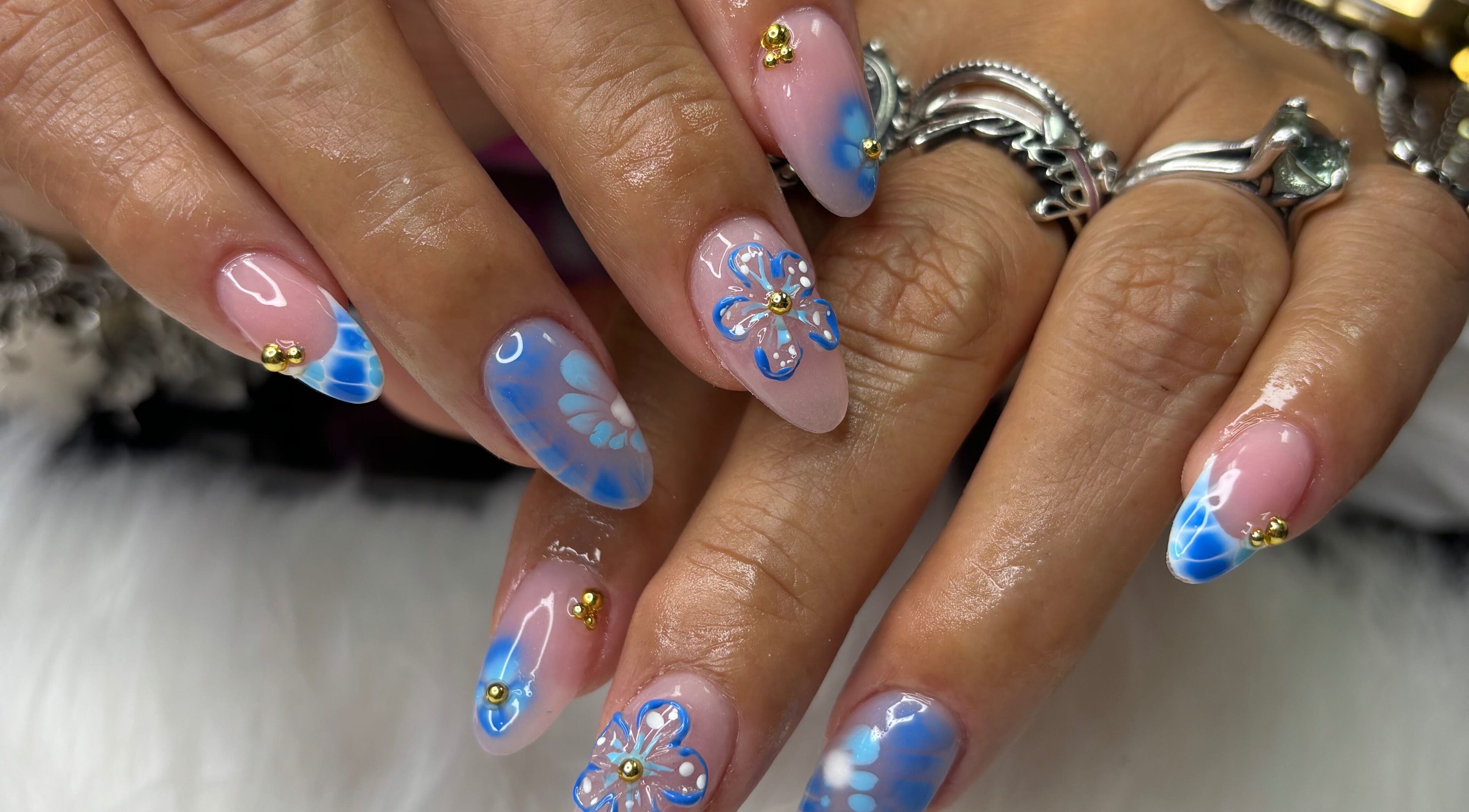 Intricate blue floral nails at Destiny's nail room in San Antonio, Texas, US. Unique nail art design.
