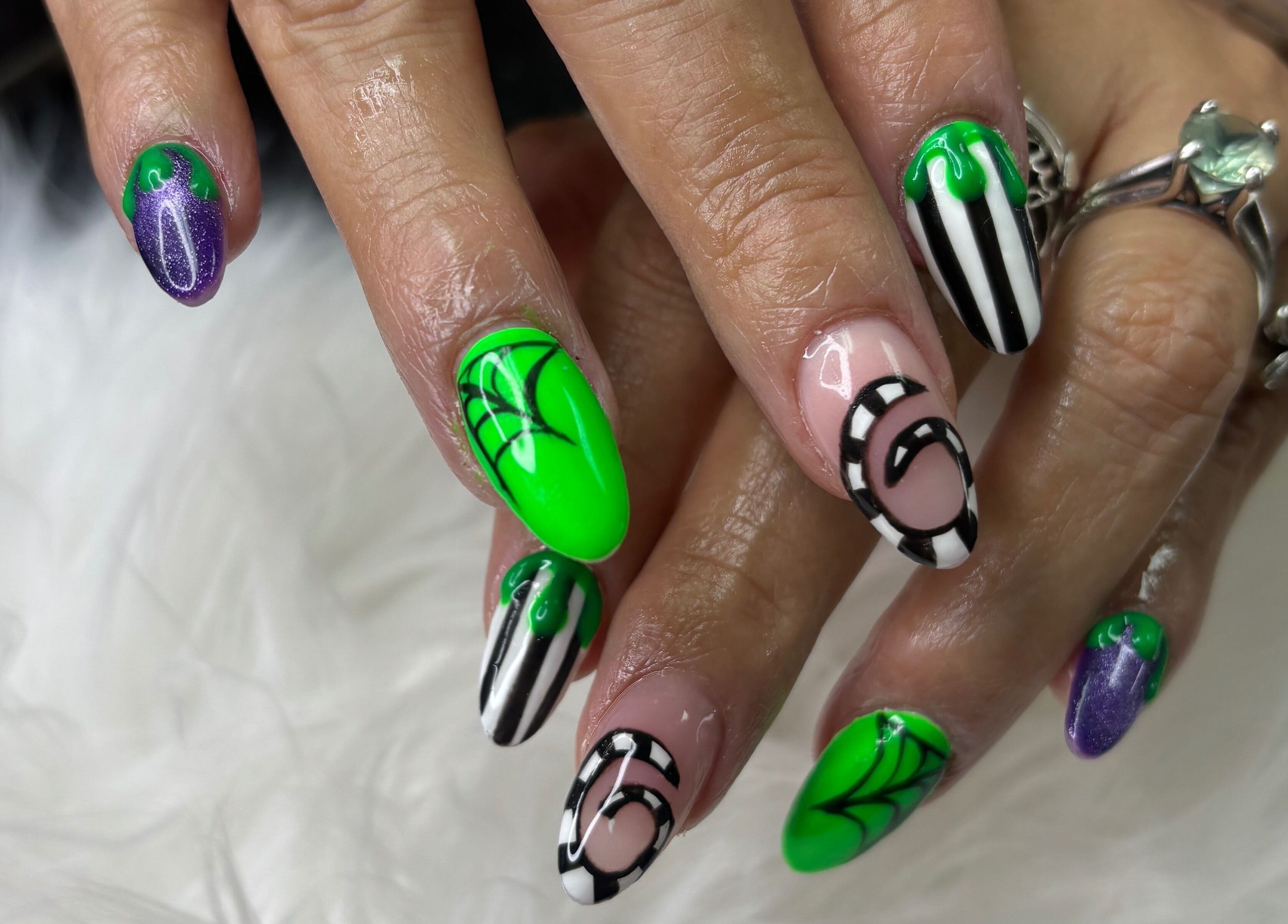 Vibrant spiderweb nail art at Destiny's Nail Room in San Antonio, Texas, US, featuring green and black designs.