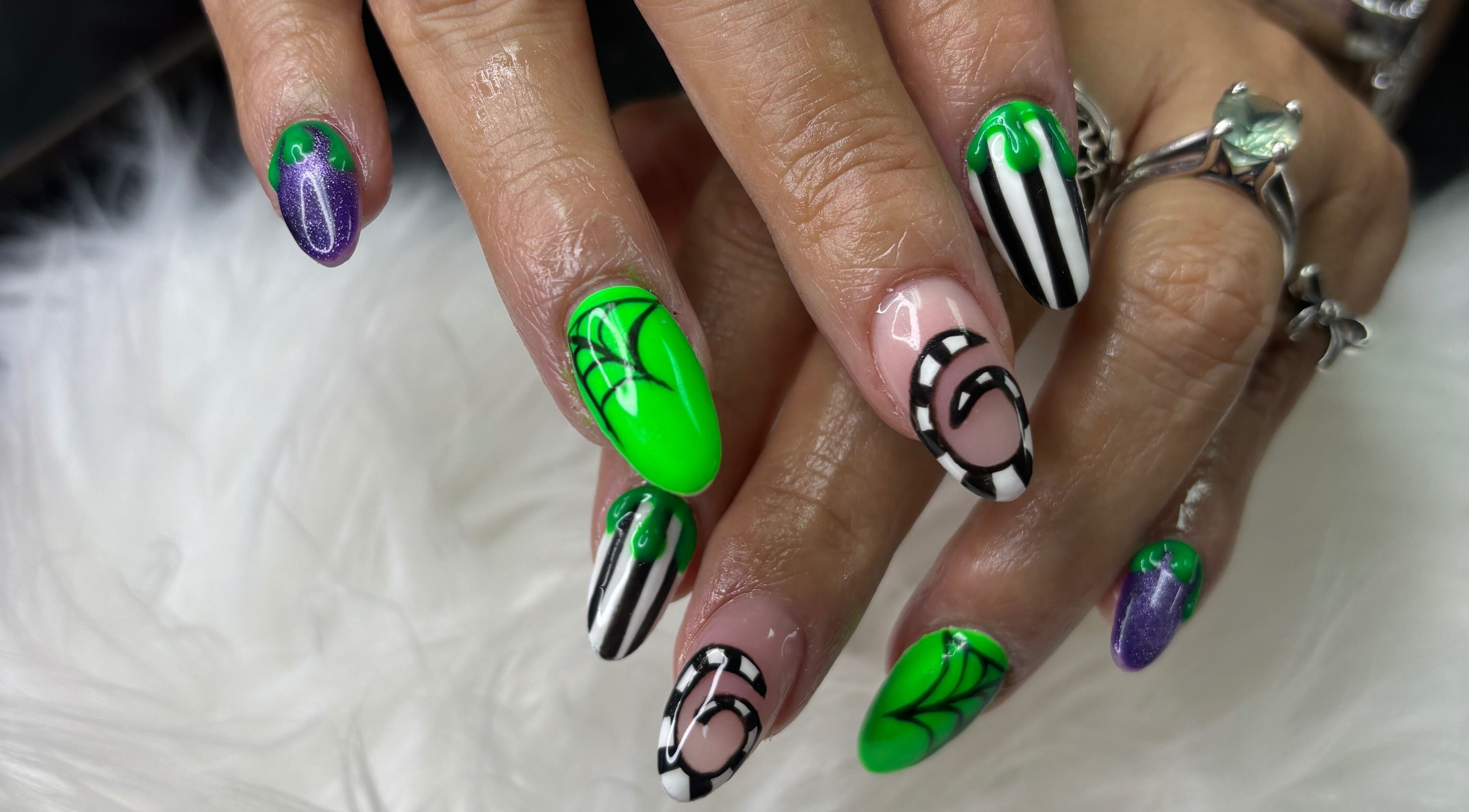 Vibrant spiderweb nail art at Destiny's Nail Room in San Antonio, Texas, US, featuring green and black designs.