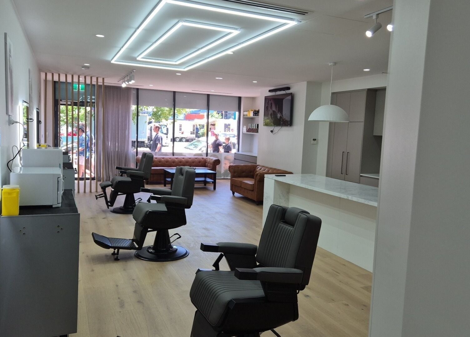 Sleek interior of THE MANUAL BARBER in Braddon, Australian Capital Territory, AU with stylish chairs and bright lighting.