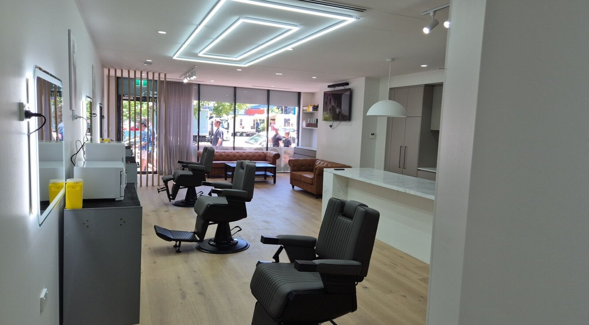 Sleek interior of THE MANUAL BARBER in Braddon, Australian Capital Territory, AU with stylish chairs and bright lighting.