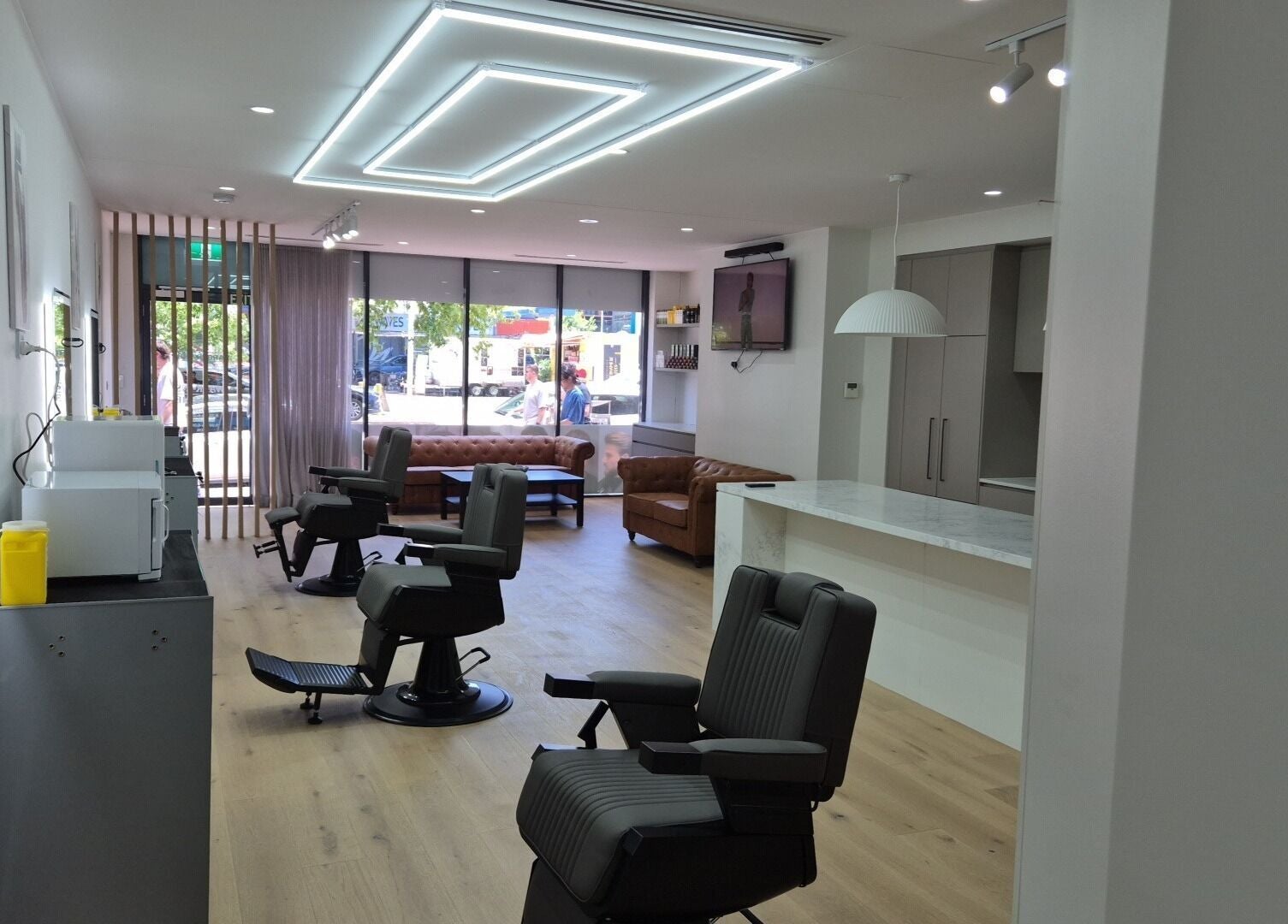 Interior of THE MANUAL BARBER, Braddon, Australian Capital Territory, AU, featuring modern barber chairs and seating.