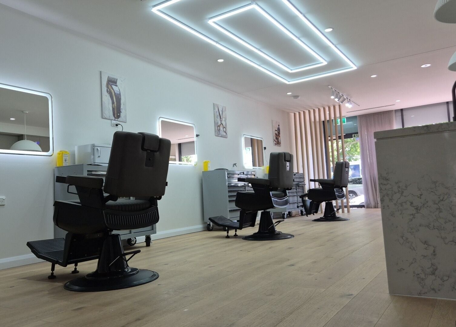 Stylish interior of THE MANUAL BARBER in Braddon, ACT, AU showcasing modern barber chairs and elegant decor.
