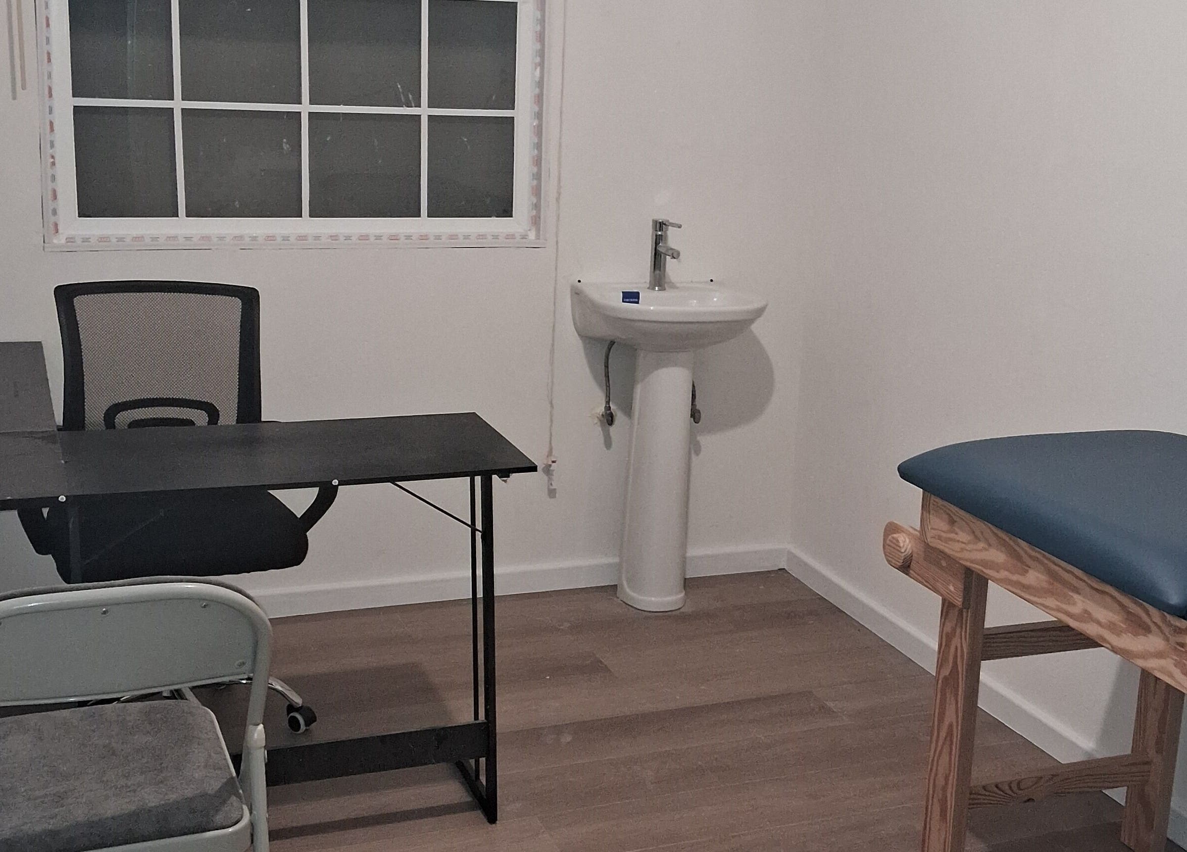Consultation room at Dolizanel Medical, Oistins, Christ Church, featuring desk and examination table.