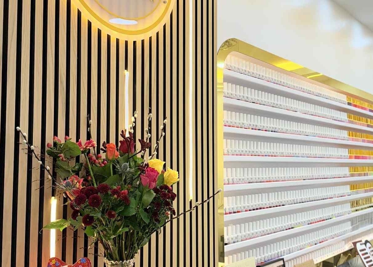 Amber Glow Nails & Beauty in London, England, GB features an elegant nail polish display and floral arrangement.