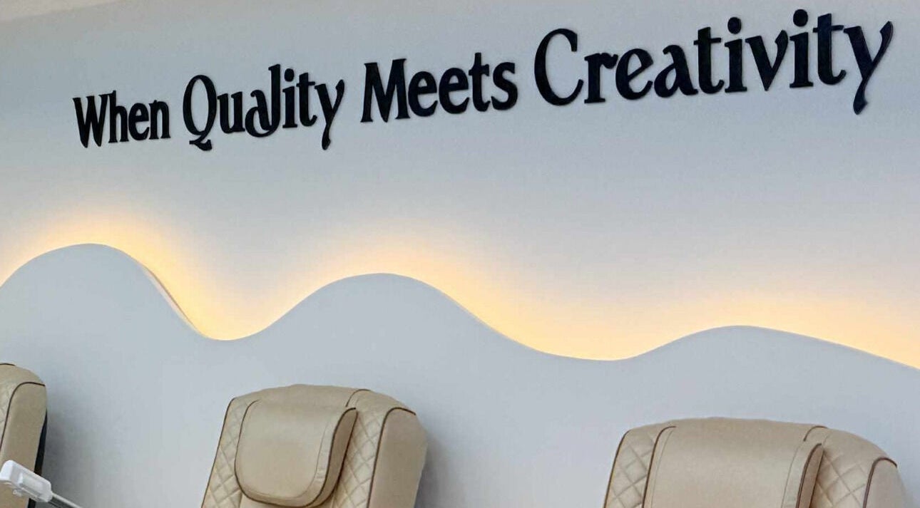 Luxurious seating with creative wall at Amber Glow Nails & Beauty in London, England, GB.