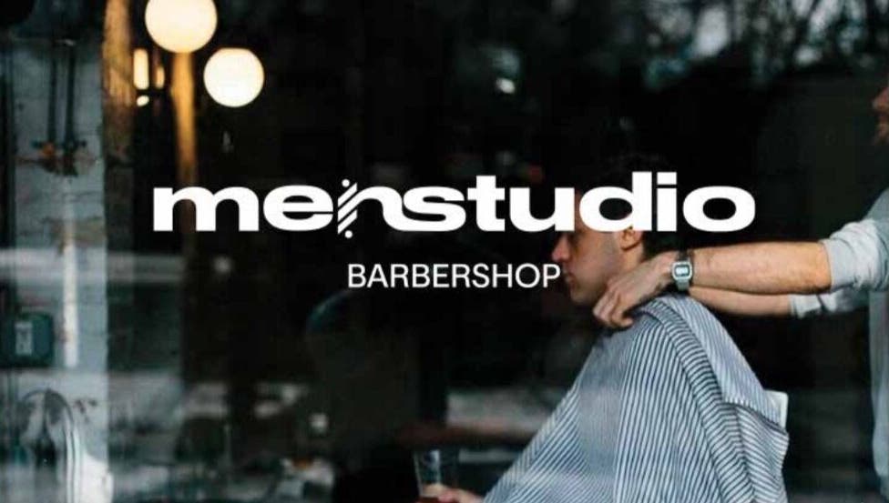 Interno di MENSTUDIO a Viganello, Ticino, CH, con cliente in sedia da barbiere.