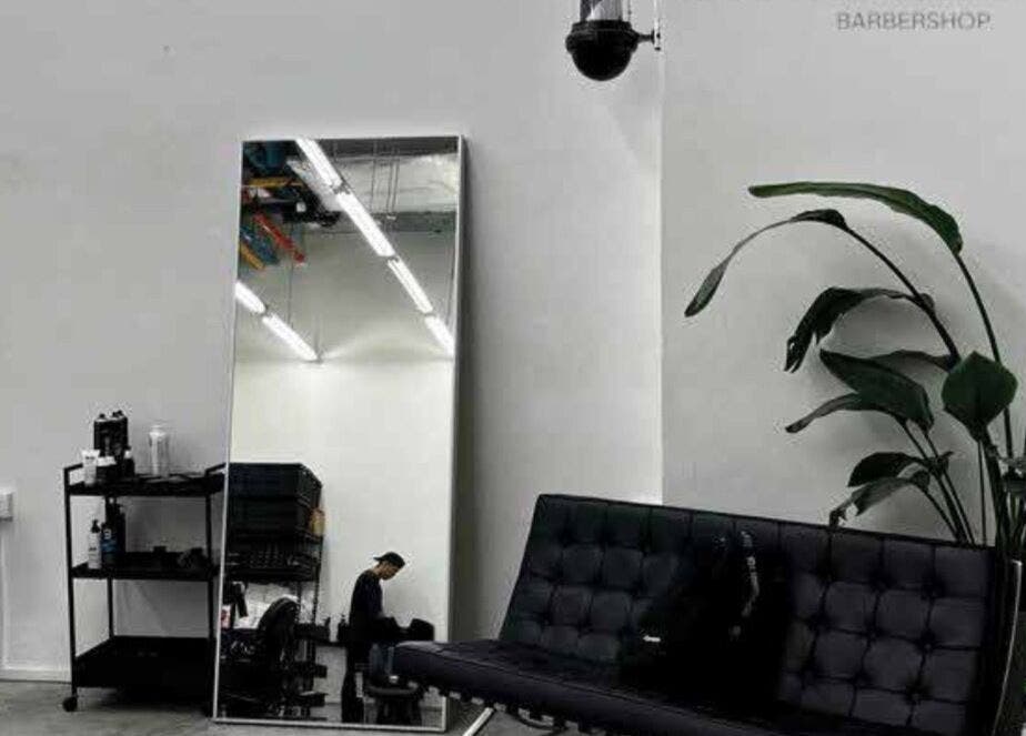 Interno moderno di MENSTUDIO a Viganello, Ticino, CH, con divano e specchio grande.