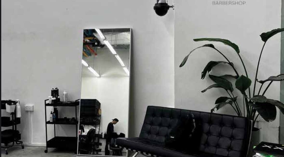 Interno moderno di MENSTUDIO a Viganello, Ticino, CH, con divano e specchio grande.