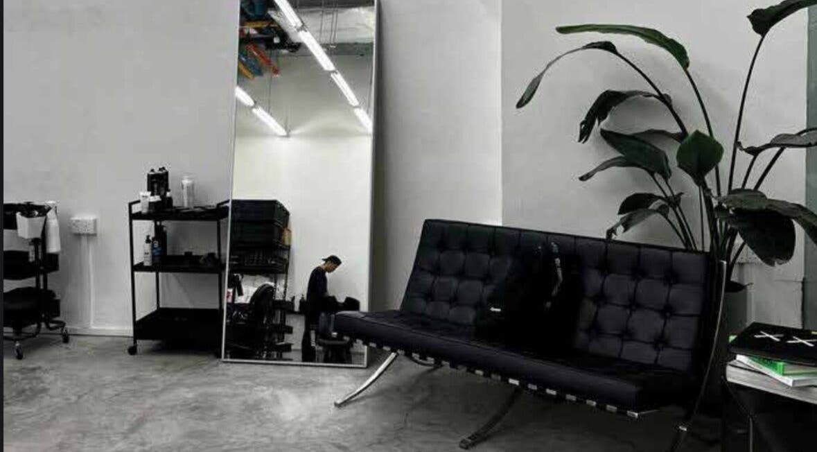 Interno elegante di MENSTUDIO a Viganello, Ticino, CH con specchio e divano moderno.