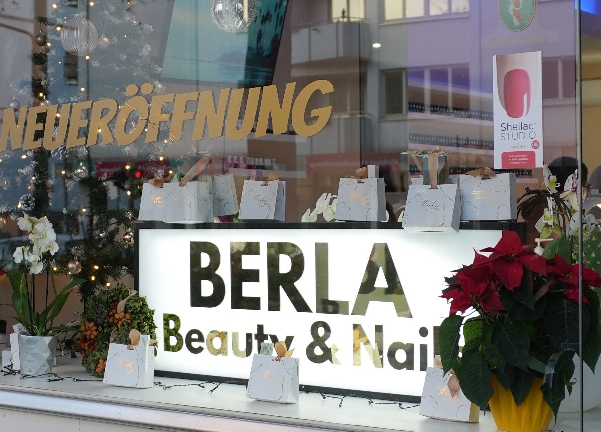Schaufenster von Berla Nails in Frankfurt Am Main, Hessen, DE dekoriert zur Neueröffnung mit Pflanzen und Geschenken.